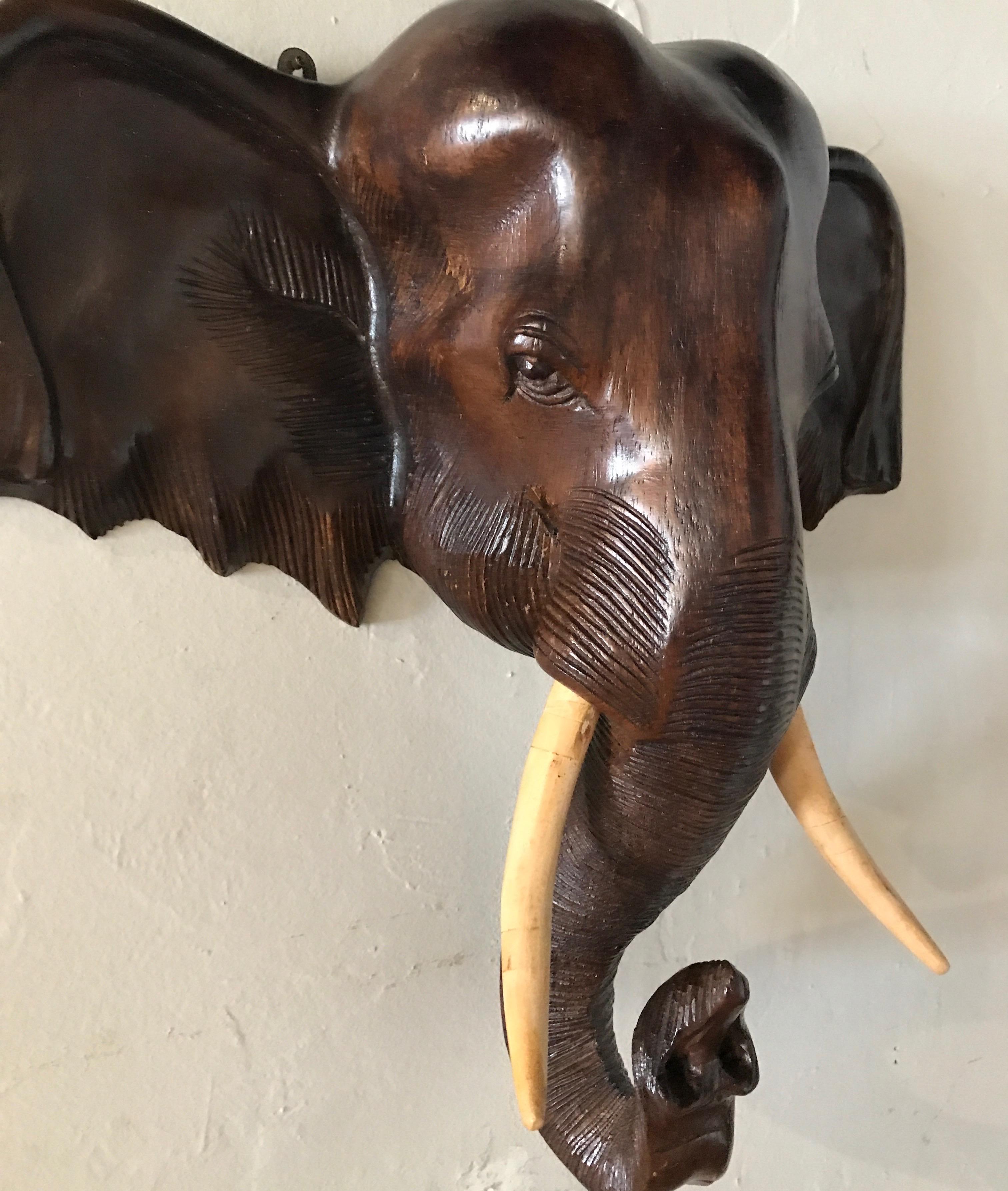 Hand carved wood elephant head with tusks.