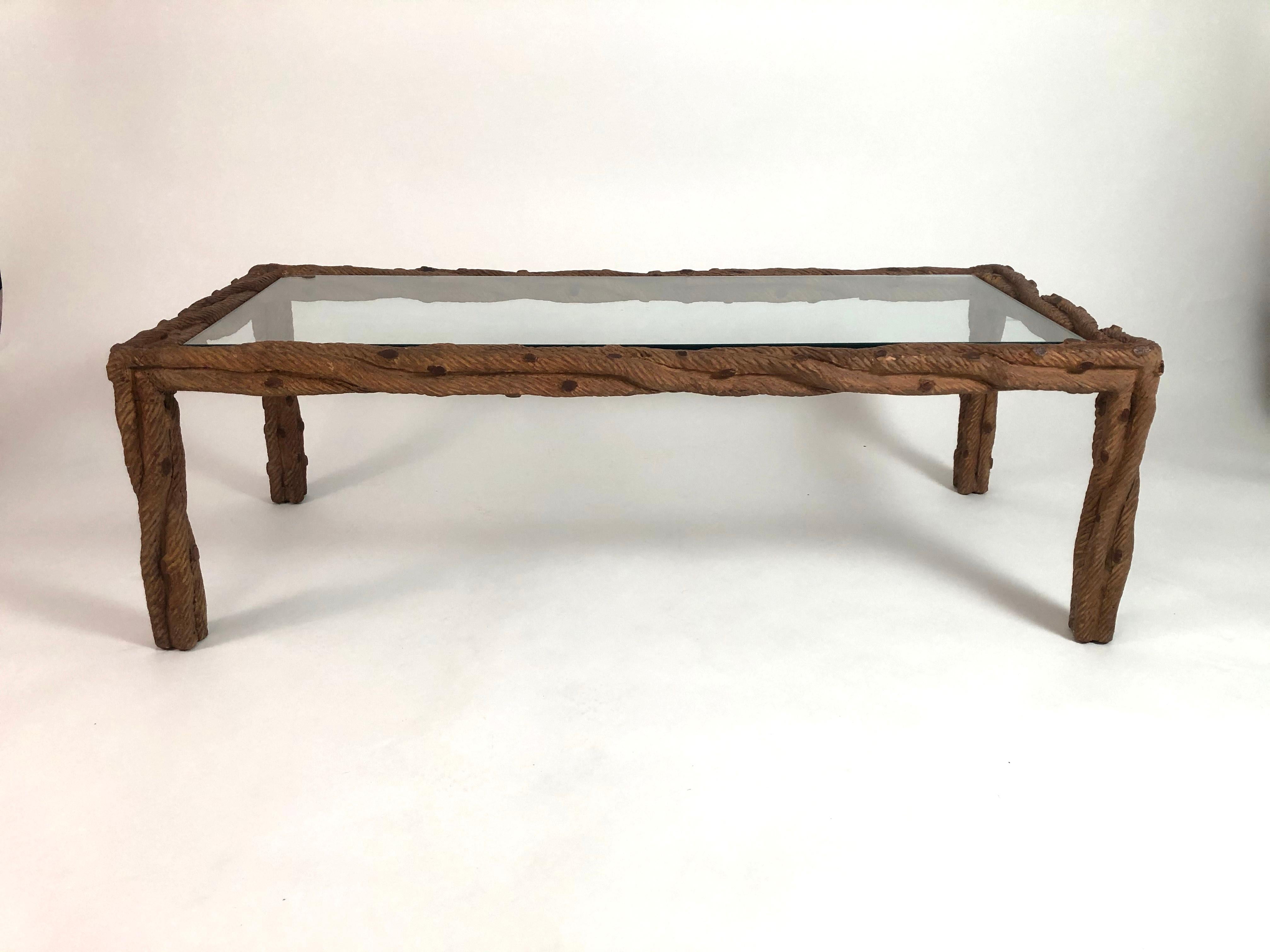 A stylish hand carved wood faux bois (but real wood) rectangular coffee or cocktail table, the legs and frame carved in the form of interlocking tree branches, with an inset, removable glass top.