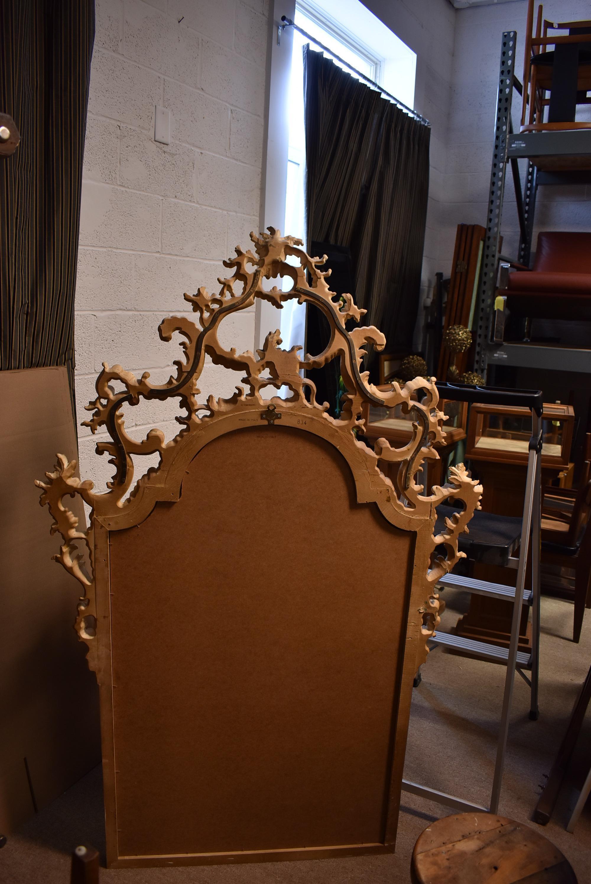 Ornate Italian Renaissance style wood mirror with soft gold finish. Beveled glass. Hand carved frame with floral details. Very good condition. Dimensions: 2