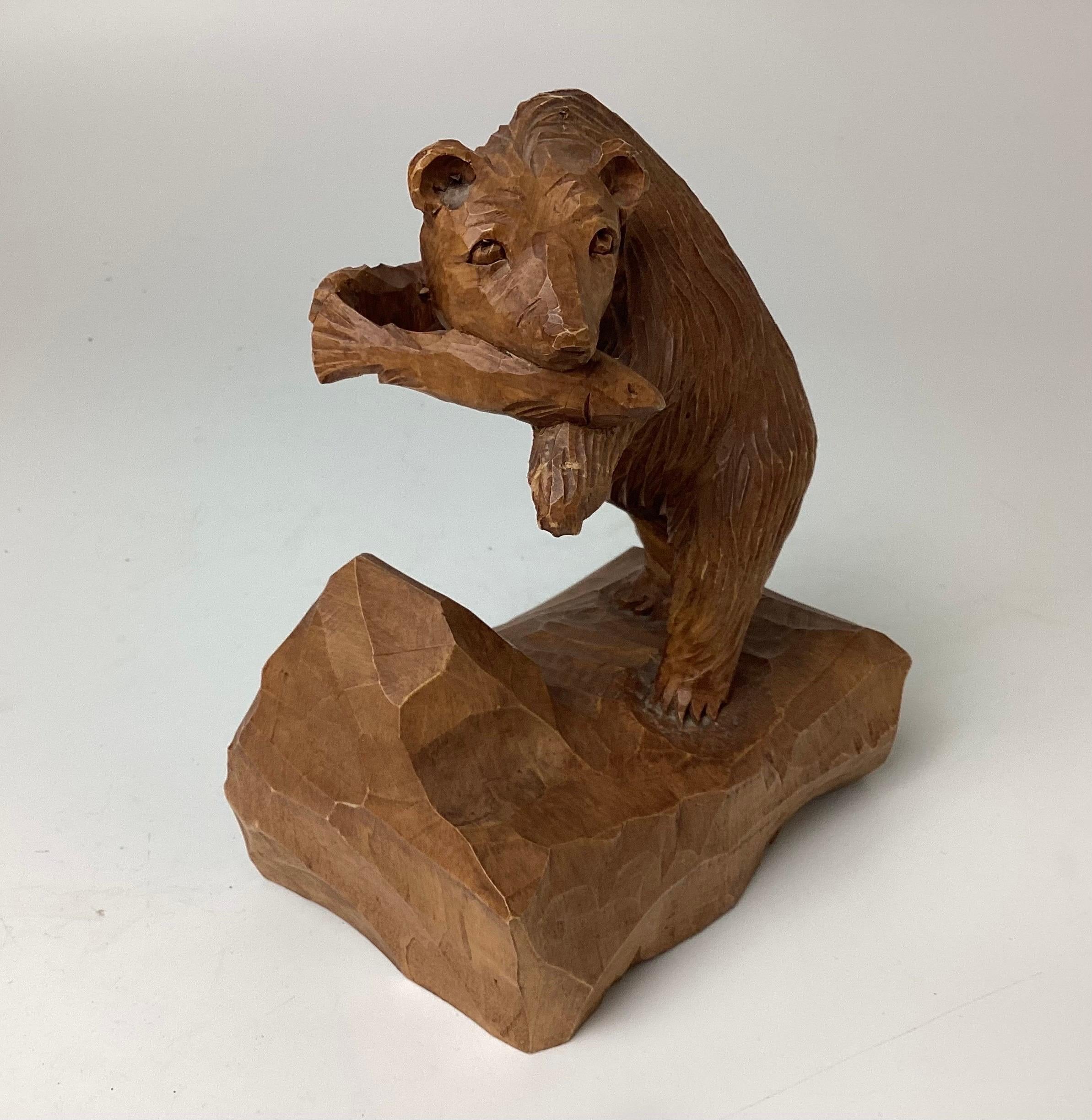 Hand Carved wood hunting bear with fish sculpture by Denys Heppell. This hand carved wood bear stands 7