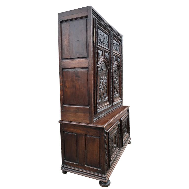 Importante armoire à deux corps à quatre portes en noyer, sculptée à la main, datant du XVIIe siècle et de la période de la Renaissance. La pièce se présente en trois parties qui sont détachables. Le bas, le haut, et la couronne. Le meuble est posé