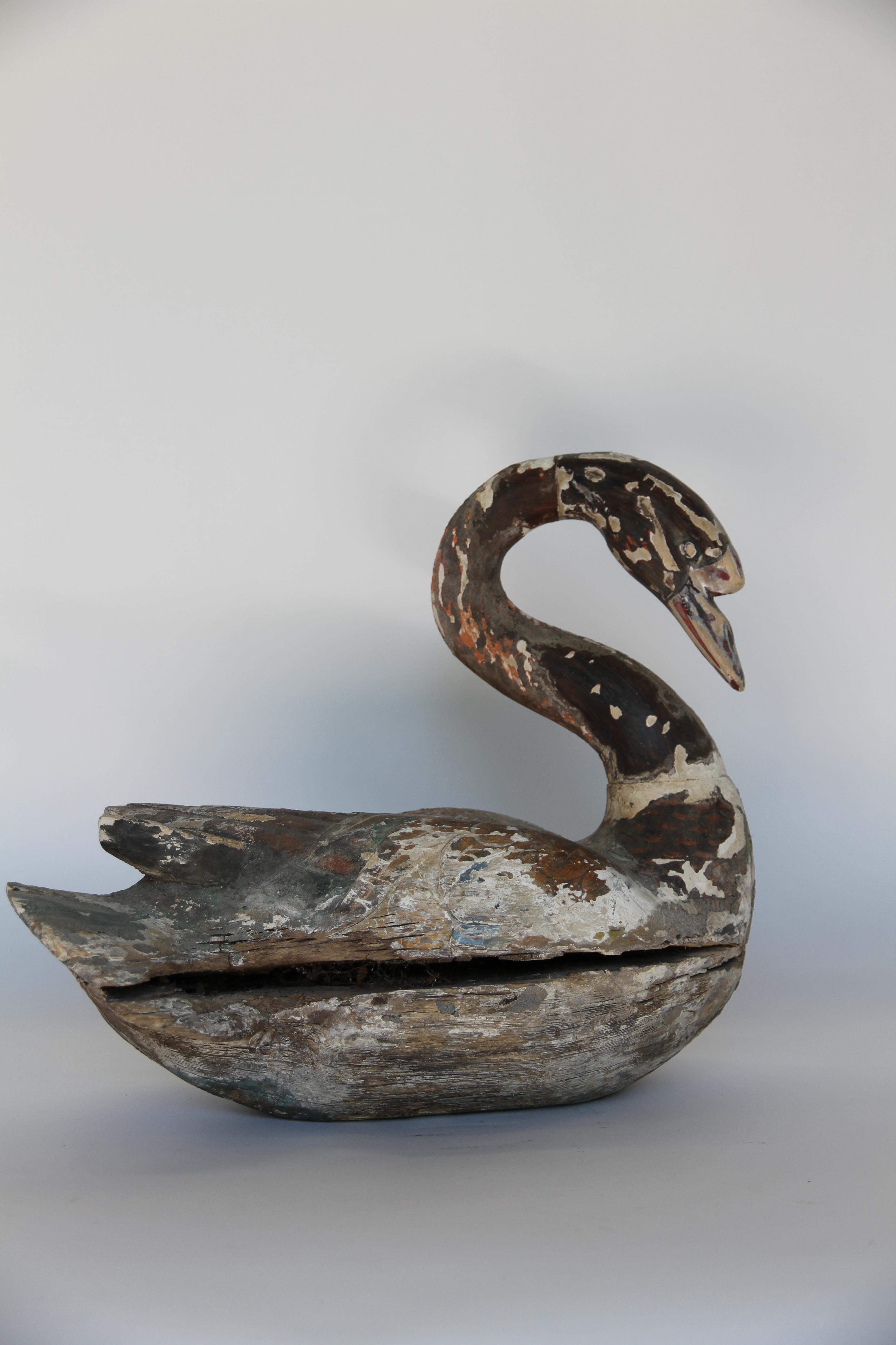 Found in France, a beautiful hand-carved swan with a lovely worn painted patina. This swan was carved from two pieces of wood, the body and the neck and head, which are joined together at the neck.