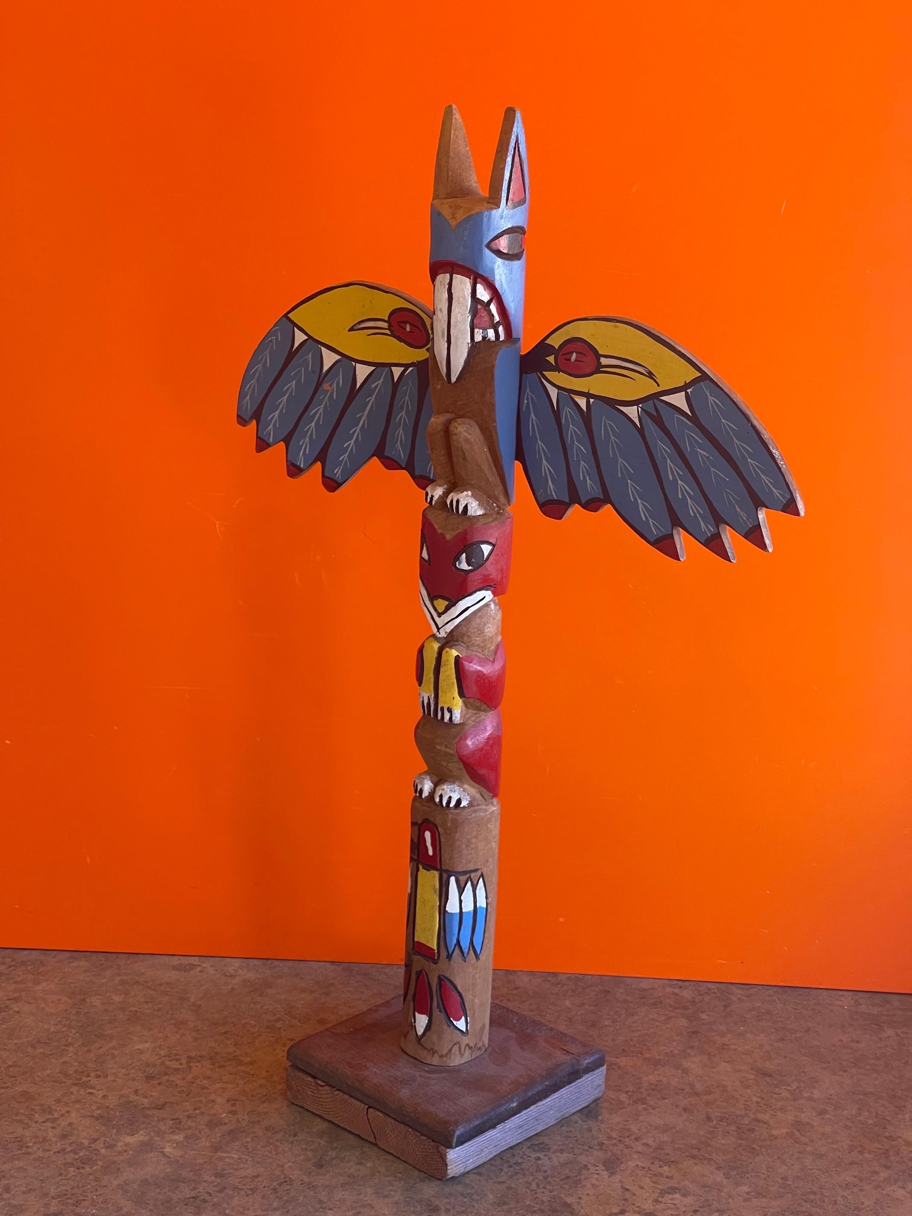 A very nice hand carved and painted wood totem pole, circa 1970s. The totem stands and 26