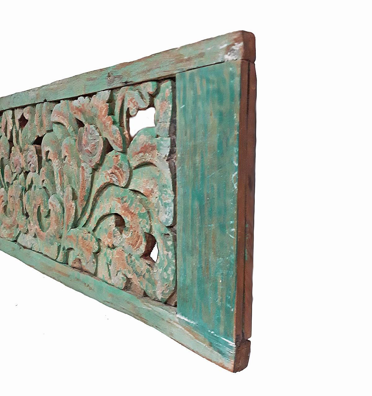 An early 20th century teak wood panel from Indonesia, intricately hand carved with a floral motif and polychromed in deep green, circa 1900.
