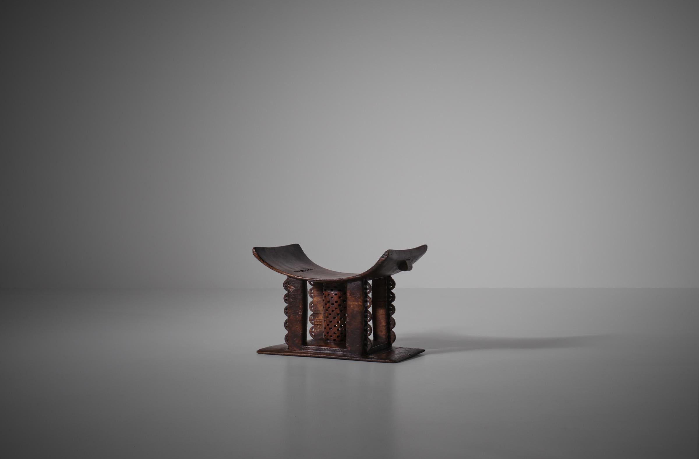 Original hand carved African tribal Ashanti stool - Ghana, early 20th century. Very nice details carved out of one solid piece of wood. The curved seat is supported by a decorative center cylindrical column and four stems which rises out of the flat