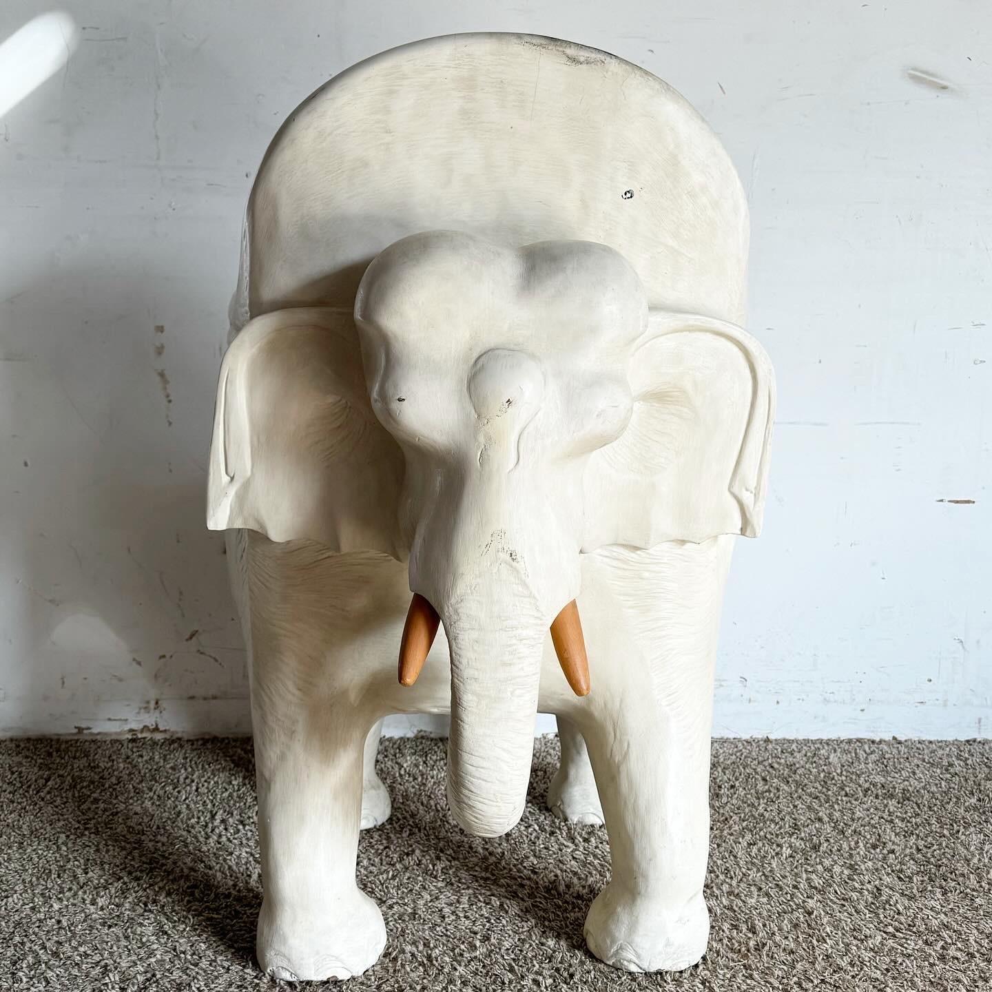 Bringen Sie einen Hauch von Laune und Kunstfertigkeit in Ihren Raum mit diesem handgeschnitzten Elefanten-Akzentstuhl aus Holz, der weiß lackiert ist. Mit seinen aufwändigen Schnitzereien zeigt dieser Stuhl außergewöhnliche Handwerkskunst mit einem
