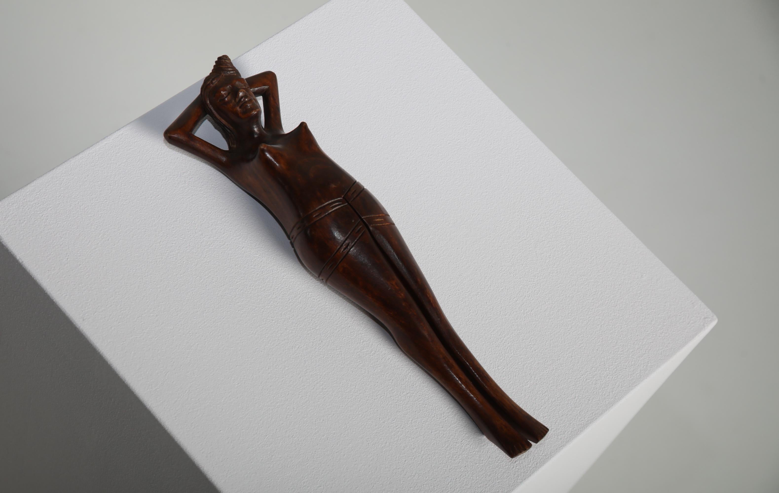 A beautifully hand-carved wooden nutcracker in the form of a reclining female figure, crafted in the mid-20th century. Made from richly toned hardwood with a smooth patina, the piece features refined detailing and a sculptural presence that elevates