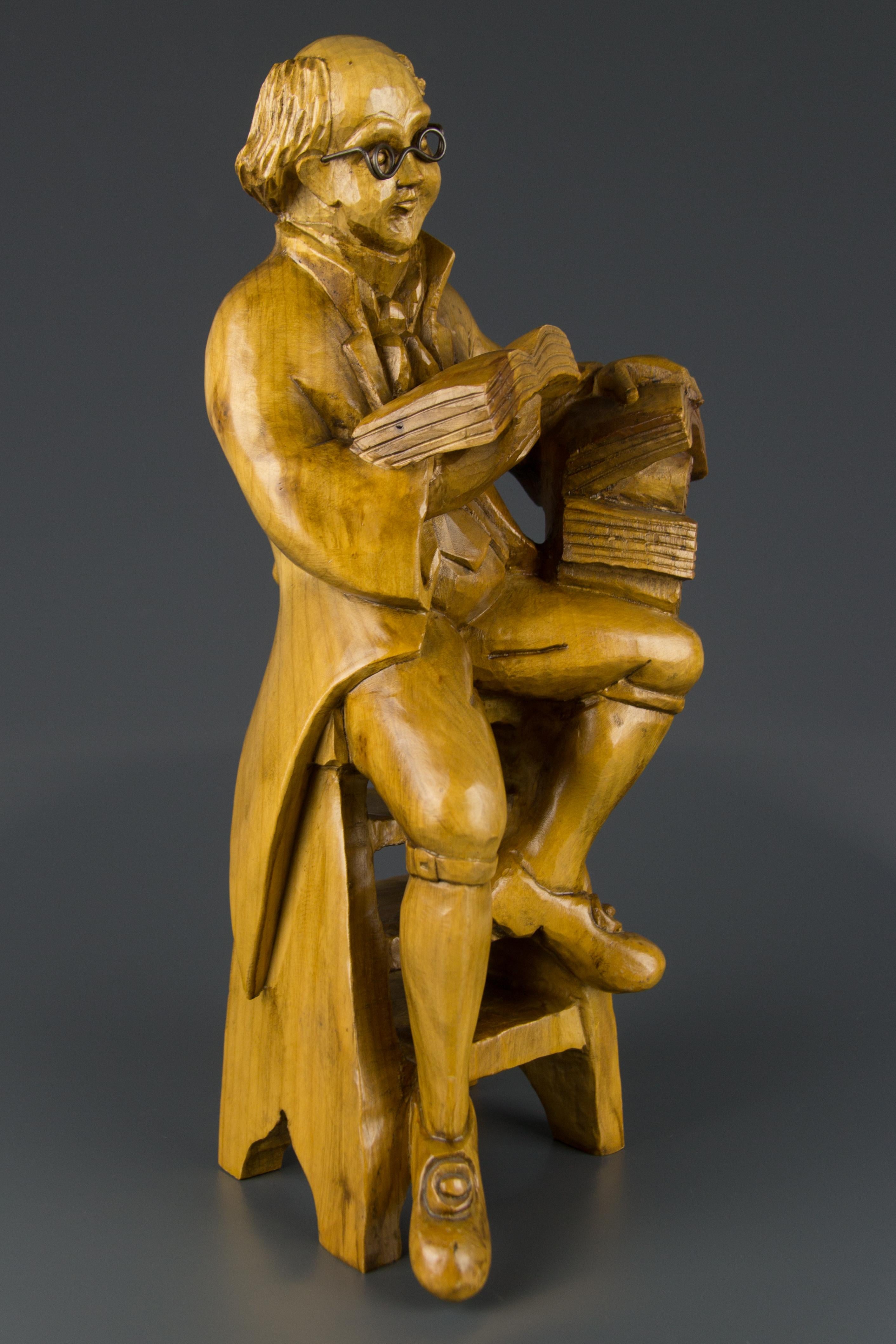 Eine meisterhaft geschnitzte Holzskulptur eines Professors mit Büchern, der auf einem Stuhl sitzt. Diese hübsche, detailgetreu gearbeitete Skulptur schmückt jeden Raum - Büro, Bibliothek, Wohnzimmer.
Abmessungen: Höhe 40,5 cm, Breite 17 cm, Tiefe