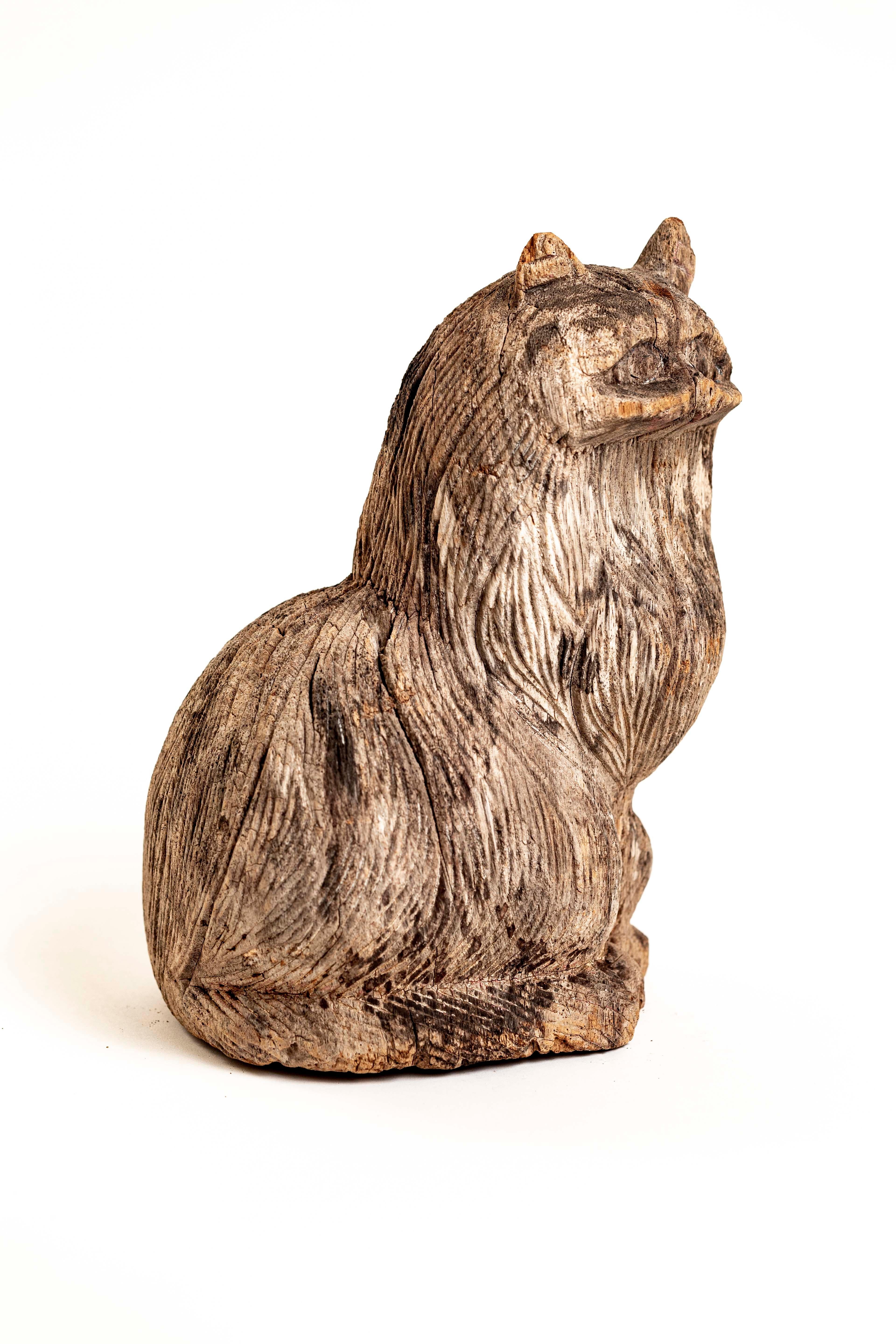 Available for purchase is a lovely sculpture of a life-sized feline friend with lots of detail and a charming personality. This vintage statue is fine example of American Folk Art, artfully hand carved from one-piece of heavy solid wood and has a