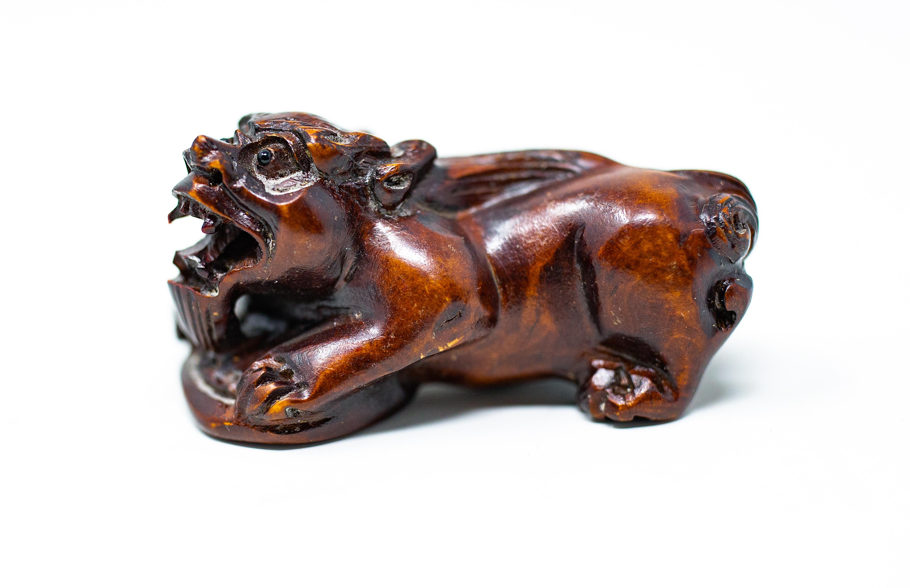 Offering these gorgeous hand carved wooden foo dogs. Carved out of a dark toned wood these little gems are interesting to the eye. Both of them are crouched over a disk like object.