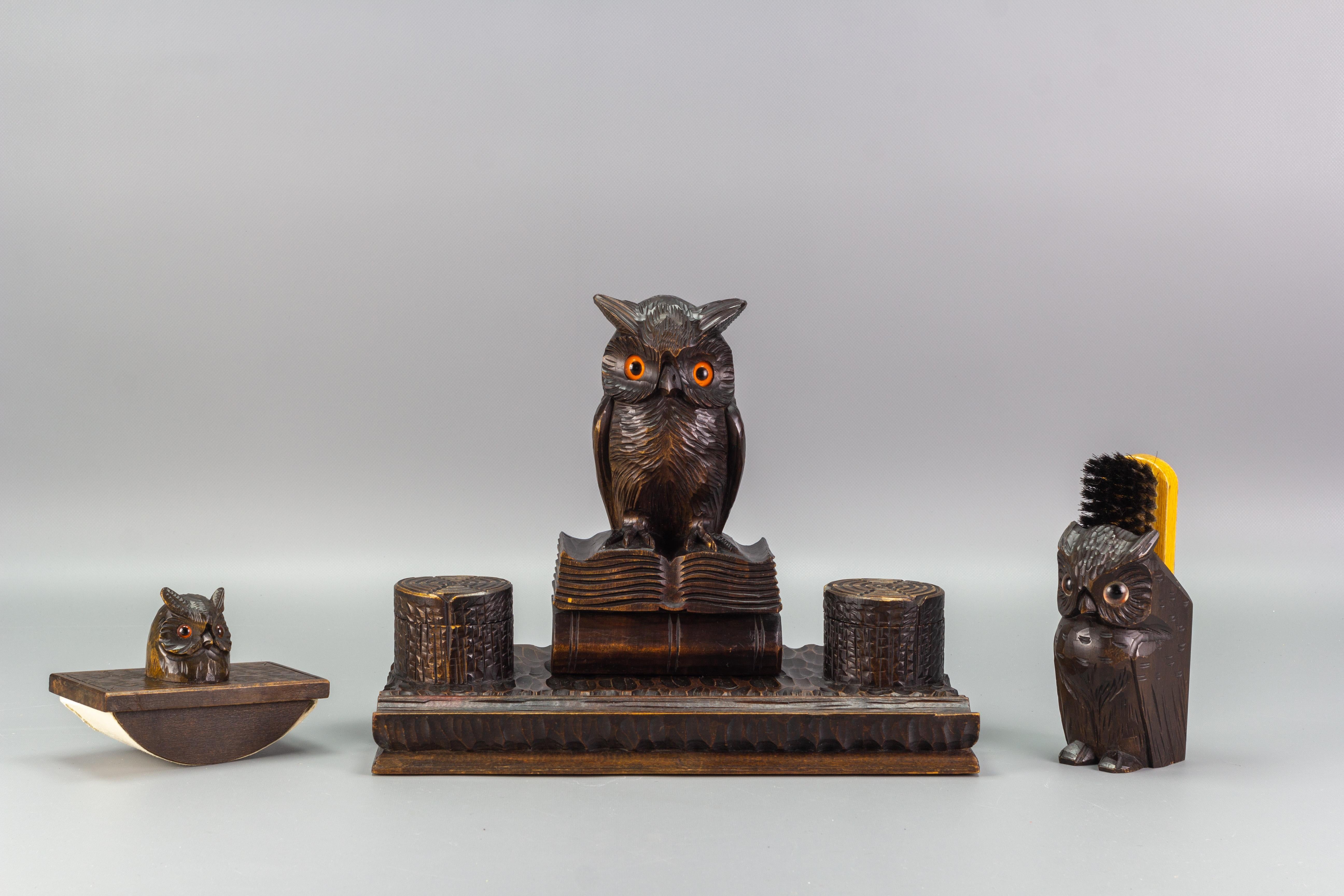 Beautiful Black Forest style hand-carved wooden double inkwell with a majestic owl figure sitting on two books. The owl has glass eyes, and the Stand has a tray for pen and accessories at the front. In the set, there is also an ink blotter and a
