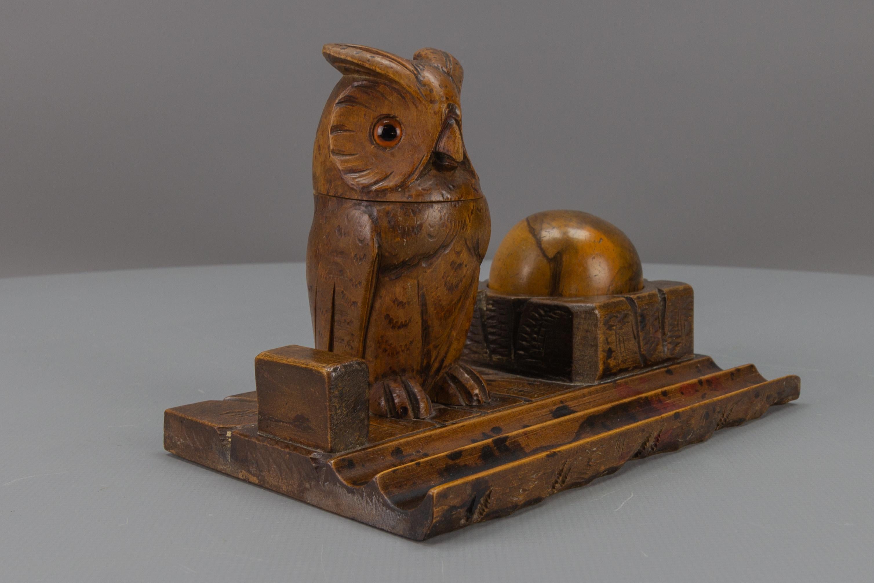 Beautiful Art Deco style hand-carved wooden inkwell or pen stand with a majestic owl figure with glass eyes. The stand features a tray for pens and accessories at the front. The head of the owl opens and there should be an inkpot but the place can