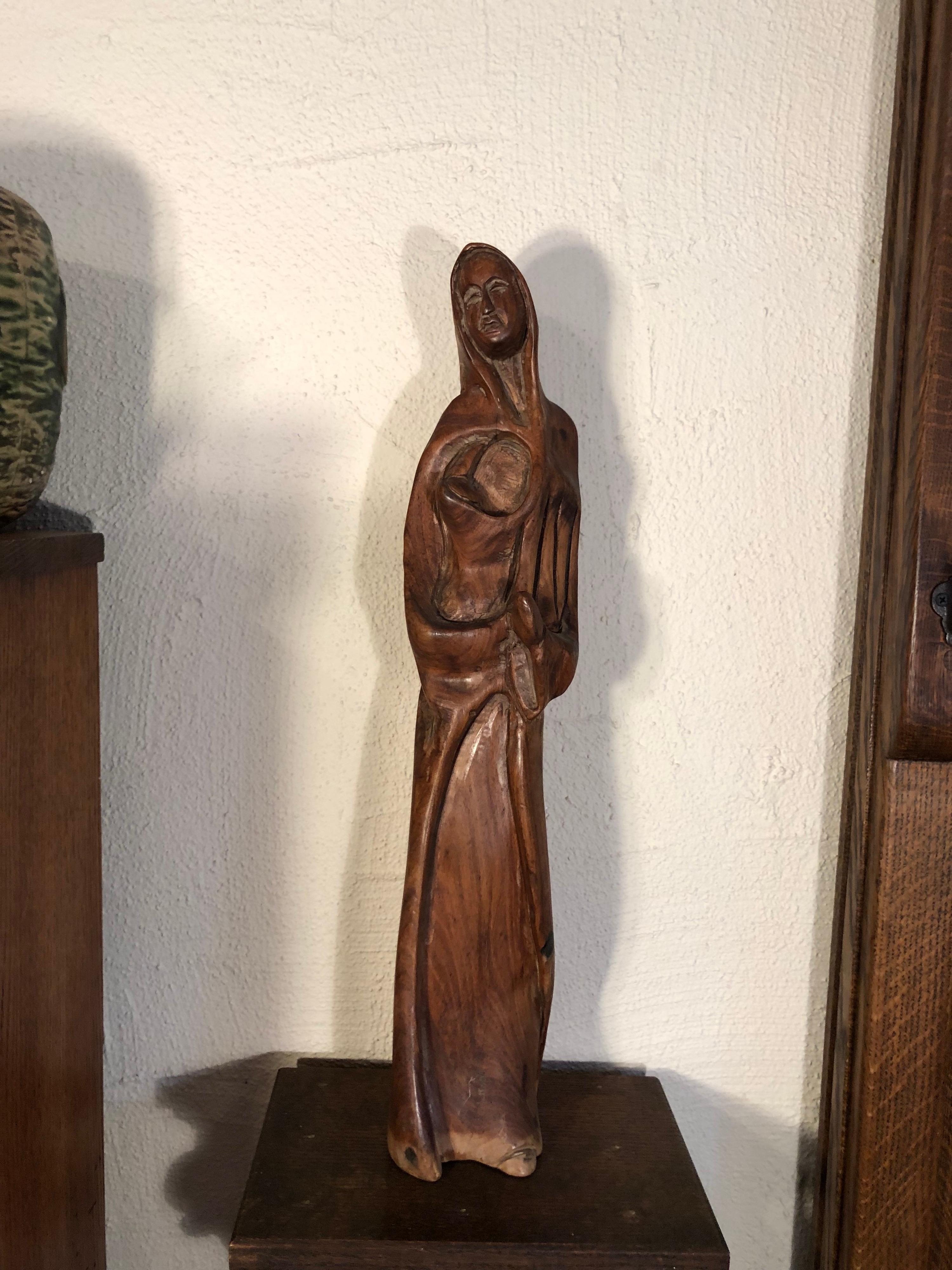 Statue de mère et d'enfant en bois sculpté à la main. Ou la Madone et l'enfant. Style moderniste du milieu du siècle. Belle et riche patine du bois avec des détails artisanaux complexes. Nous pensons que le bois est du noyer. Le colis sera expédié