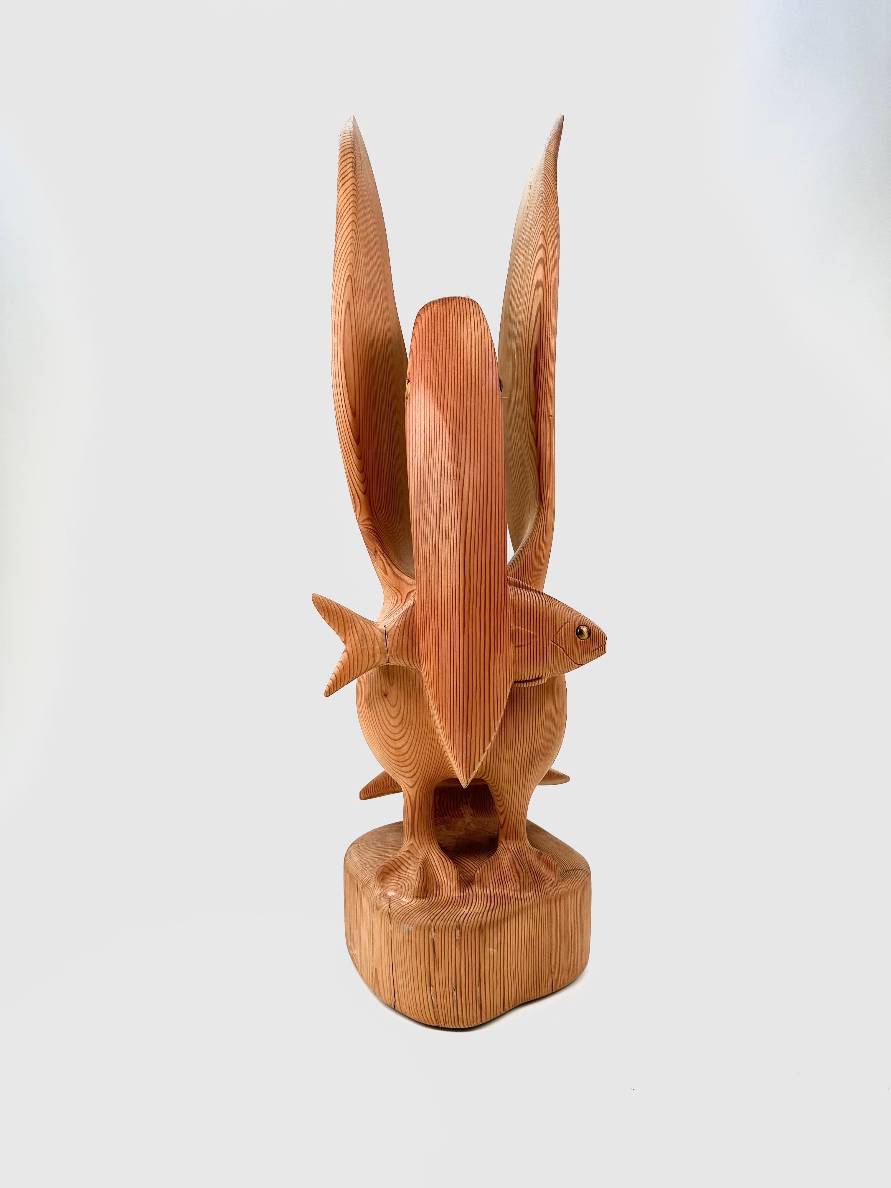Escultura de madera tallada a mano Pelícano con pez siglo XX en venta