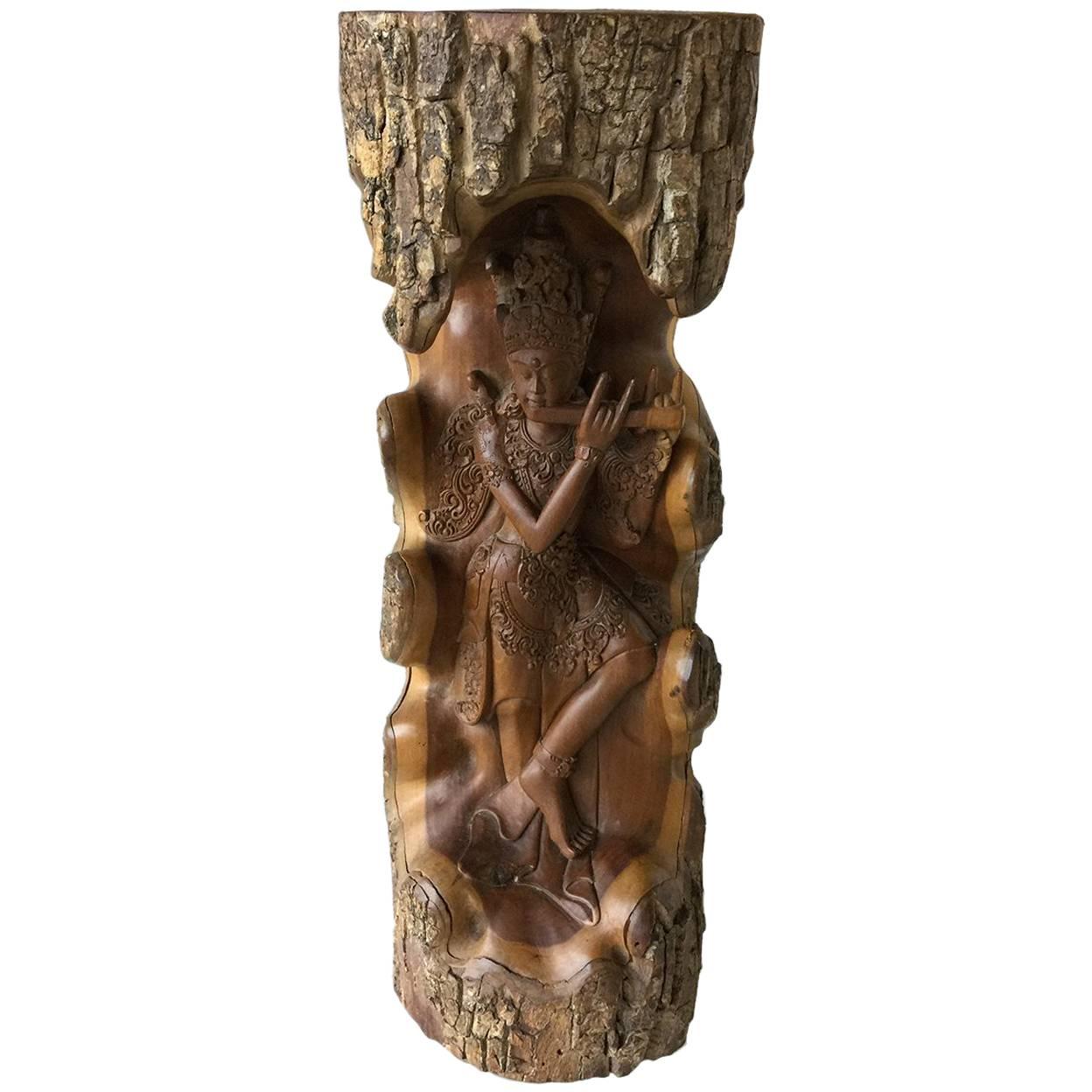 Hand-carved wooden statue with Lord Krishna from a piece of a tree