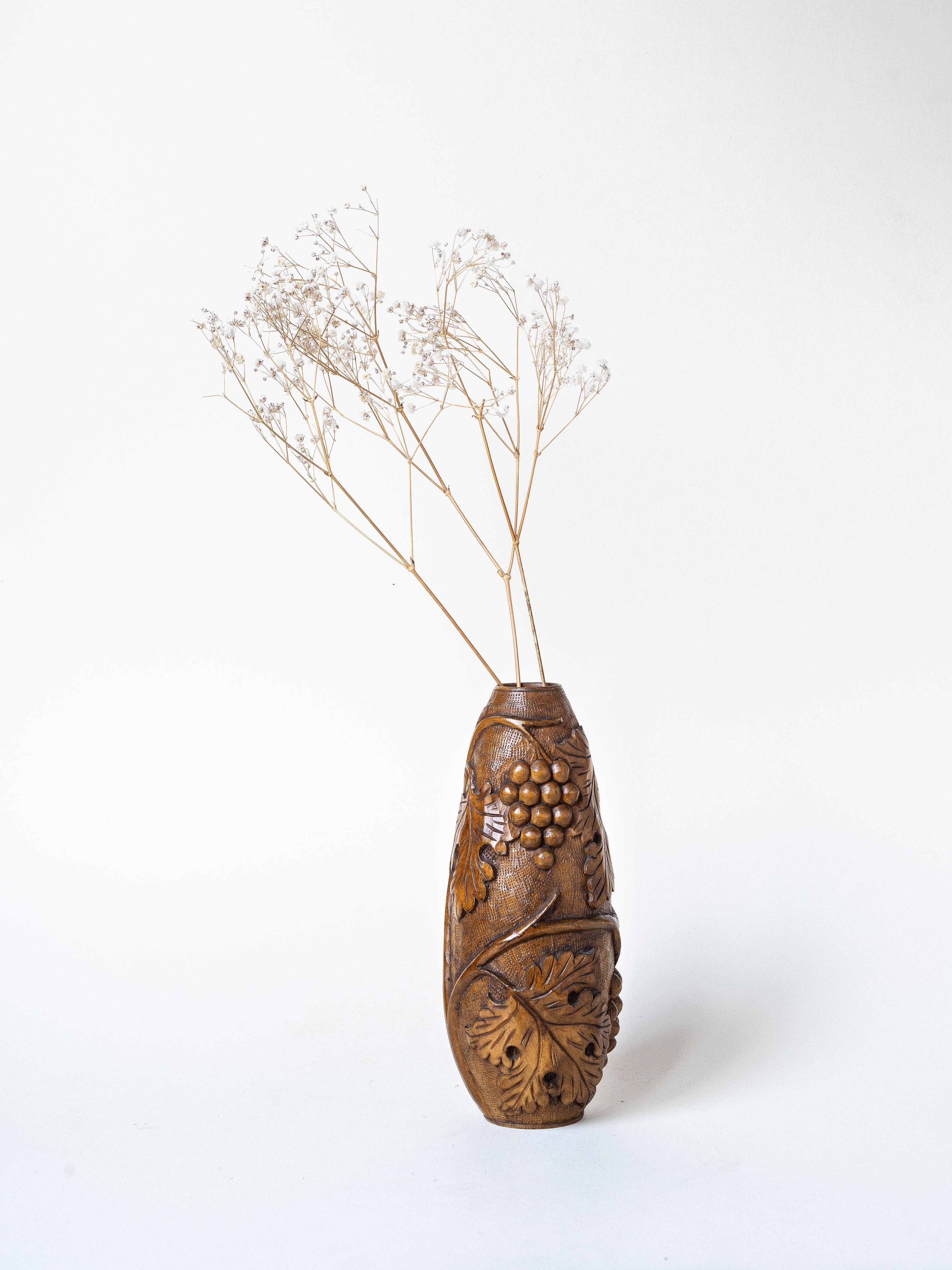 Hand-Carved Wooden Vase, Grapes and Leaves pattern, France 1960s.

Finely carved wooden vase featuring an intricate design of grape clusters and vine leaves. 

The elegant motif wraps entirely around the vase, creating a stunning visual effect from