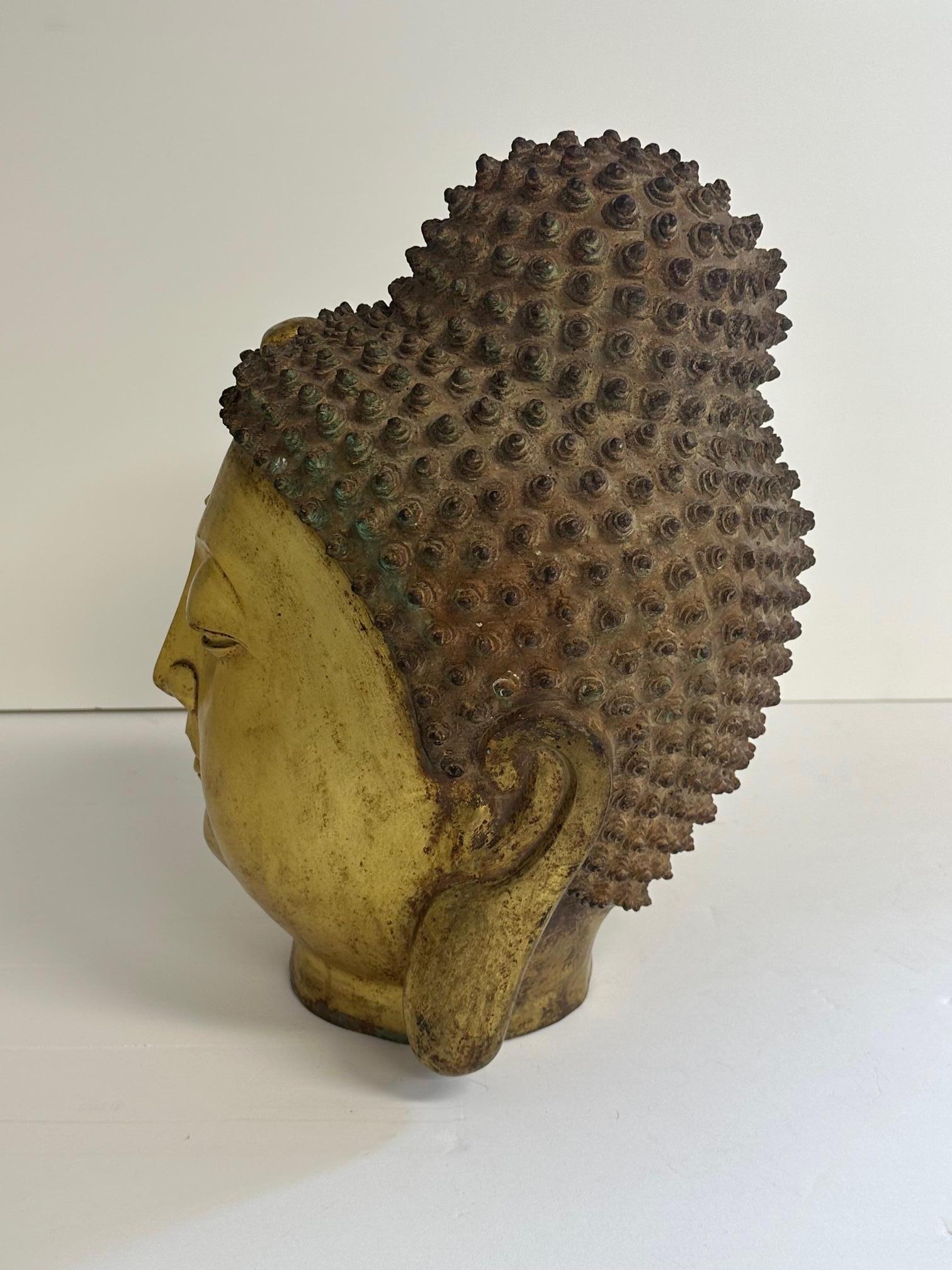 Ethereal cast brass Thai Buddha head having gorgeous patina and meticulous detail.  The closed eyes give an incredible sense of serenity in the sculpture.
