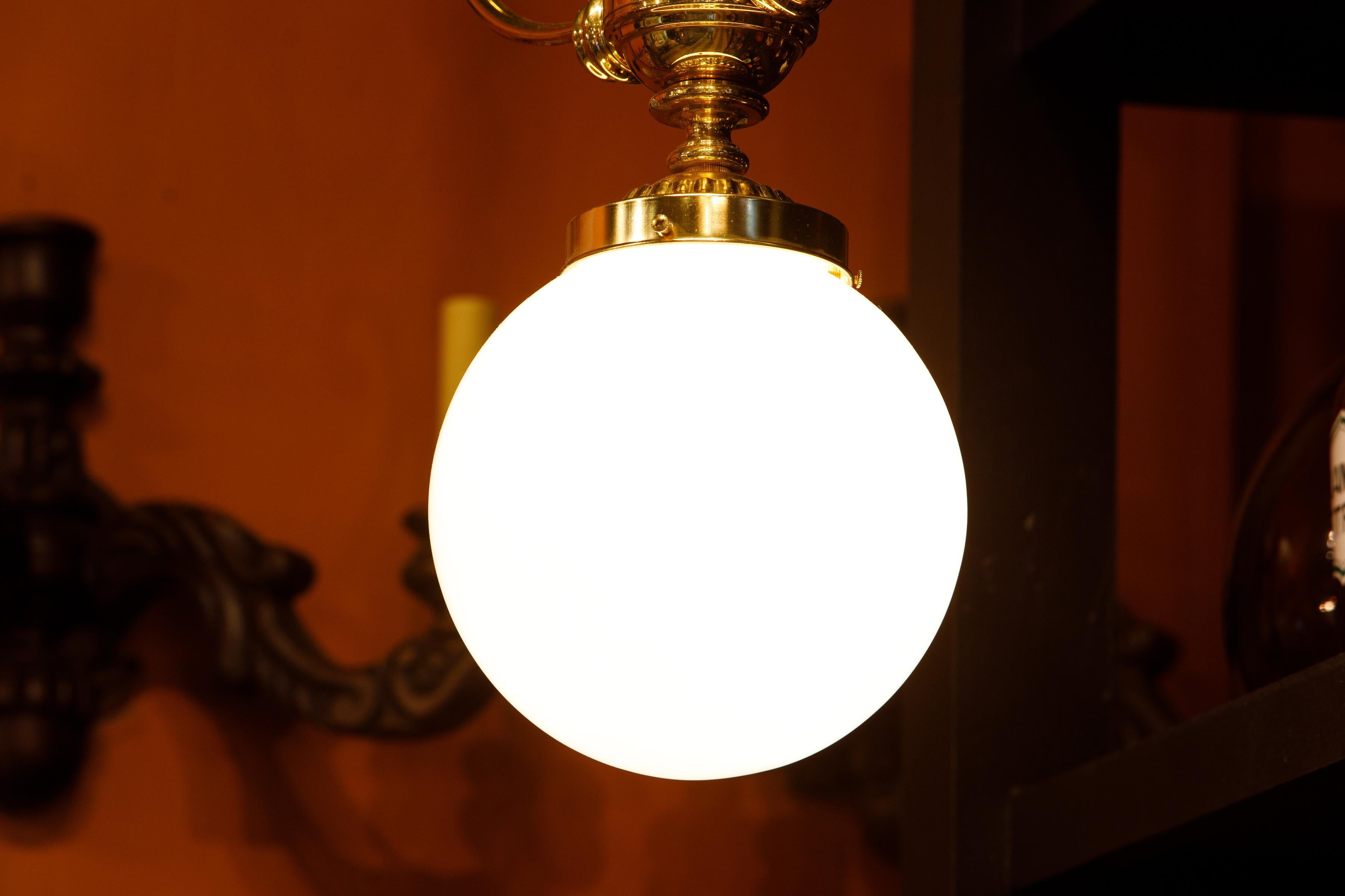 Lampe à suspension longue en laiton espagnol coulé à la main avec boule en verre dépoli blanc antique Excellent état - En vente à Houston, TX