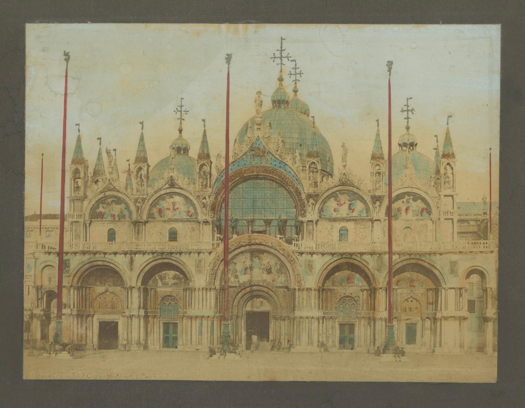Die beiden Fotografien sind handkolorierte Bilder der Piazza San Marco in Venedig, Italien, und zeigen die ikonische venezianische Architektur:

Erstes Bild:
- Thema: Die breitere Ansicht des Markusplatzes mit dem Campanile di San Marco (dem hohen