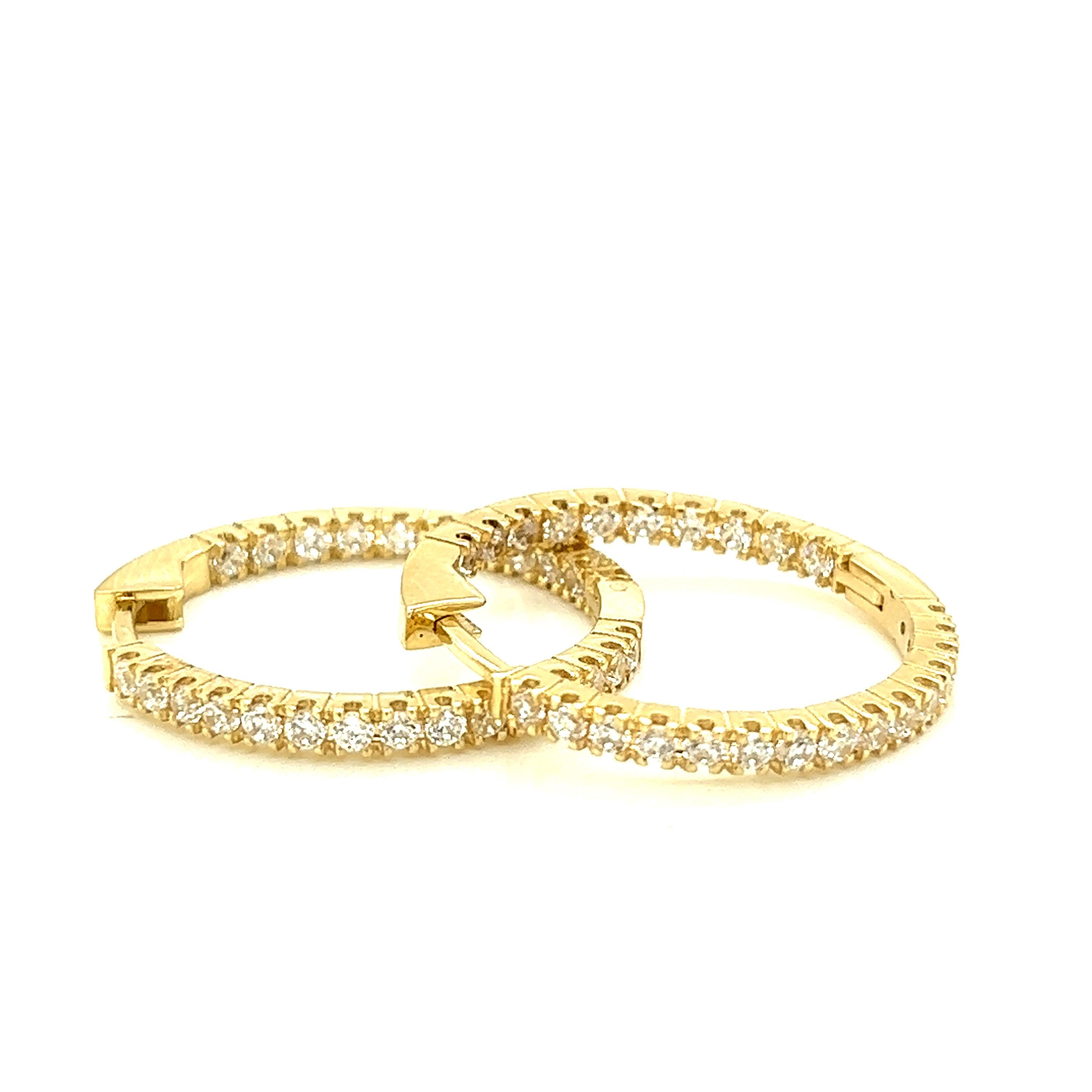 14 Karat Yellow Gold Hand-Crafted Polish-Finished 25mm Inside-Out Eternity Diamond Hoop Earrings, Set with 1.25 Carats Diamonds and a Hinge-Post Closure.
