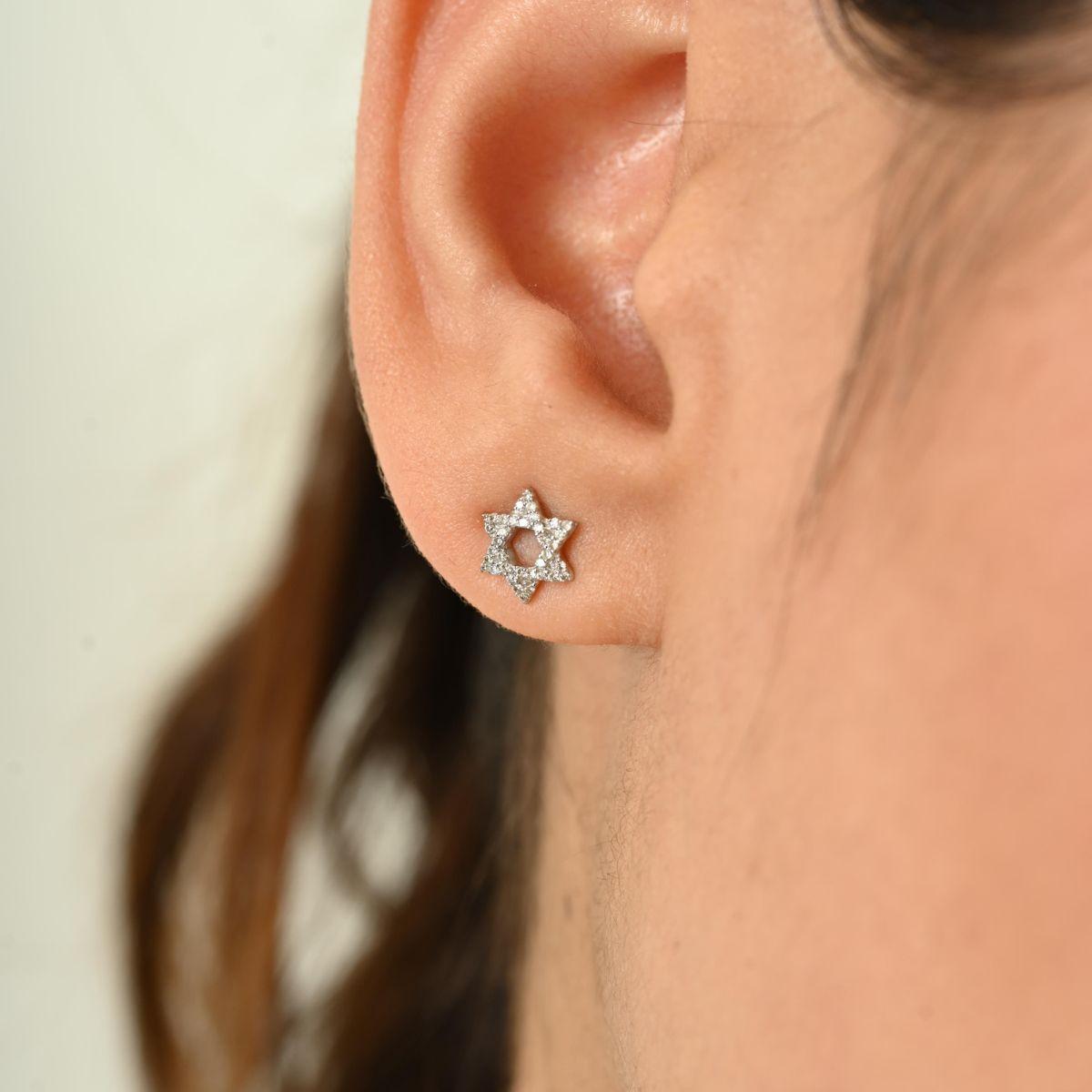 Ajoutez un éclat céleste à votre look avec ces élégantes boucles d'oreilles en forme d'étoile, délicatement serties de diamants brillants totalisant 0,134 carats. Réalisée en métal poli, chaque boucle d'oreille présente une silhouette en étoile à