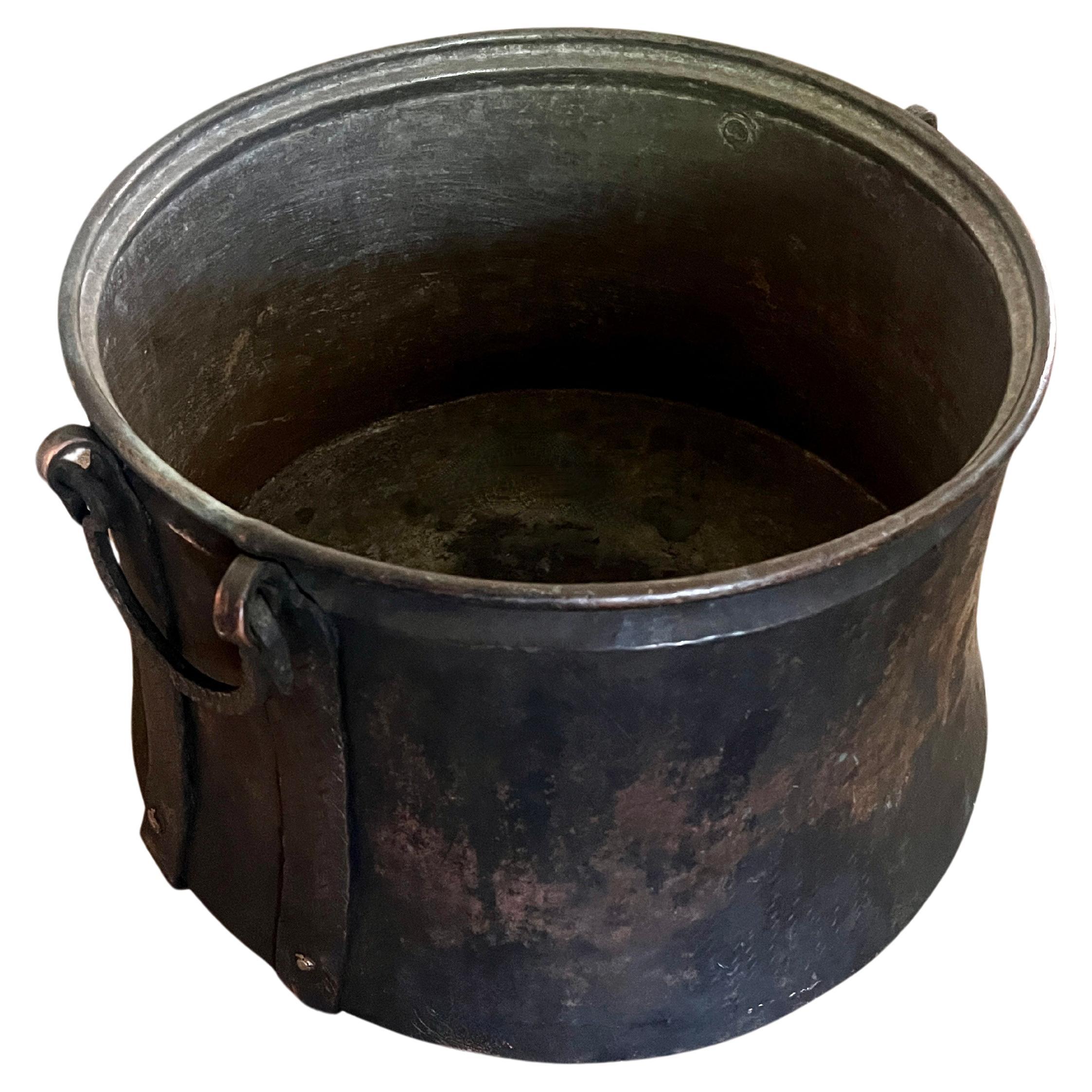 a magnificent  and very large Copper Coal, wood Bin or Cauldron with wrought iron handles.

A compliment to many spaces and wonderful for firewood, storage and also a very nice planter

The Copper is heavily patinated in the best way.  Heavy, sturdy