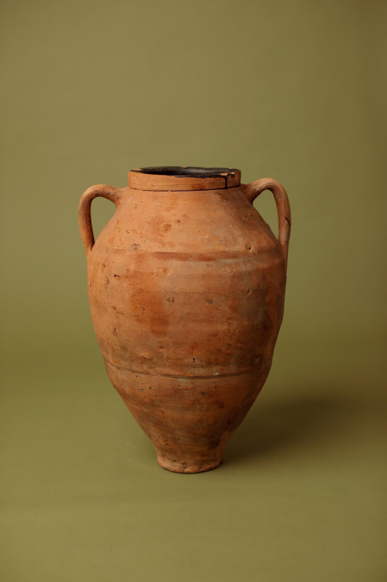 Questa giara in terracotta del XX secolo proviene dall'Anatolia centrale, dove l'argilla densa e ricca di ferro e la cottura a forno aperto producevano recipienti durevoli destinati alla conservazione e al trasporto dell'olio nelle fattorie rurali.