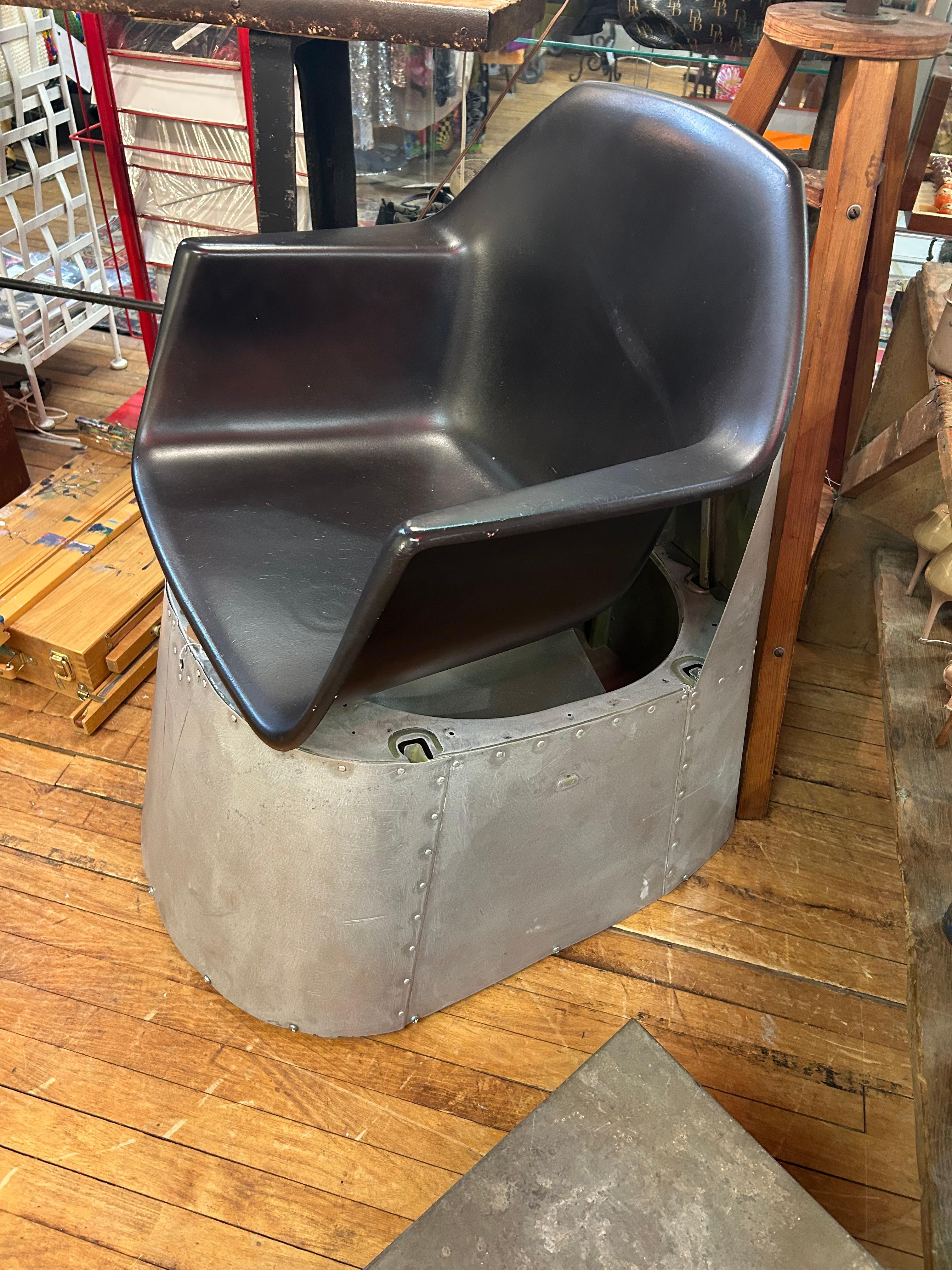 Sillón de salón superartesanal creado a partir del fuselaje de un avión Piper PA-24 Comanche de 1956, combinado con un asiento Atomic de fibra de vidrio de los años 60.