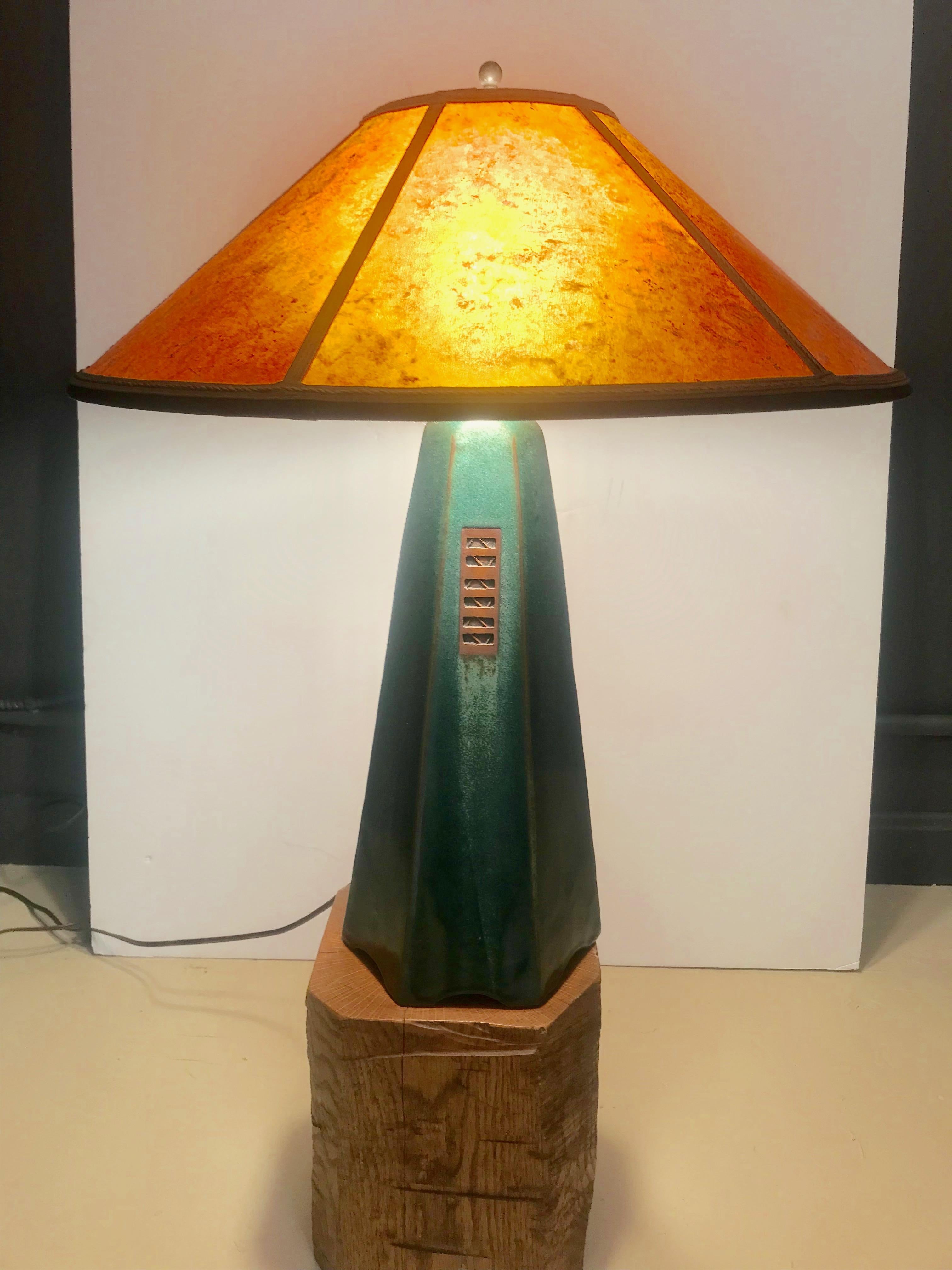 A beautiful Jim Webb original table lamp from his Hopewell Collection in a moss glaze with amber mica shade.
Dimensions:
Footprint: 7.25 x 7.25 
Height of base without hardware 15.25 total height to top of finial 22
Shade:
Bottom width diameter