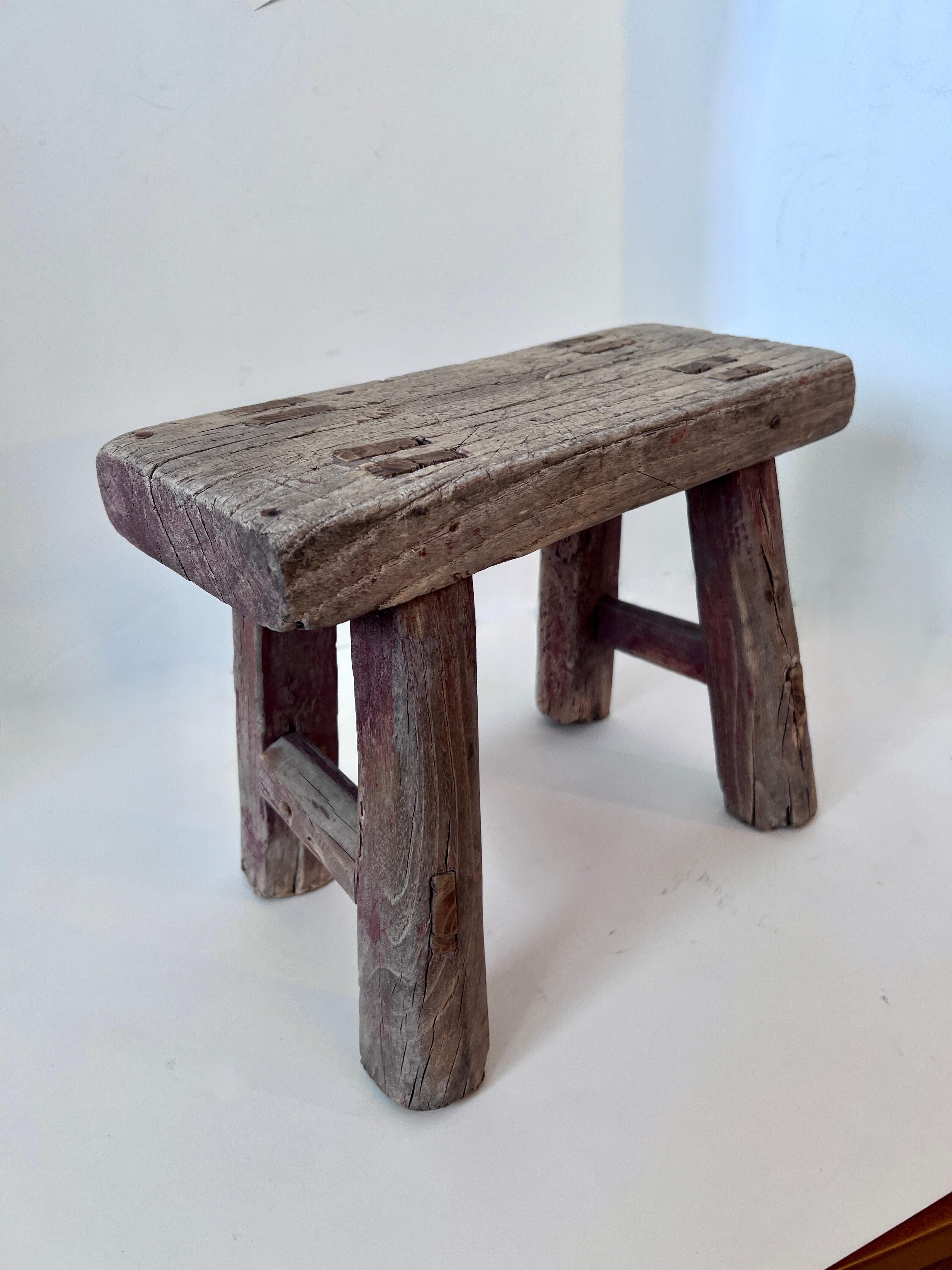 A wonderfully patinated Elm Wood Stool originating in China.  The wood is beautifully worn and in sturdy usable condition.

A compliment to many spaces and works well underneath a console or side table - pull out to seat children or to put up ones