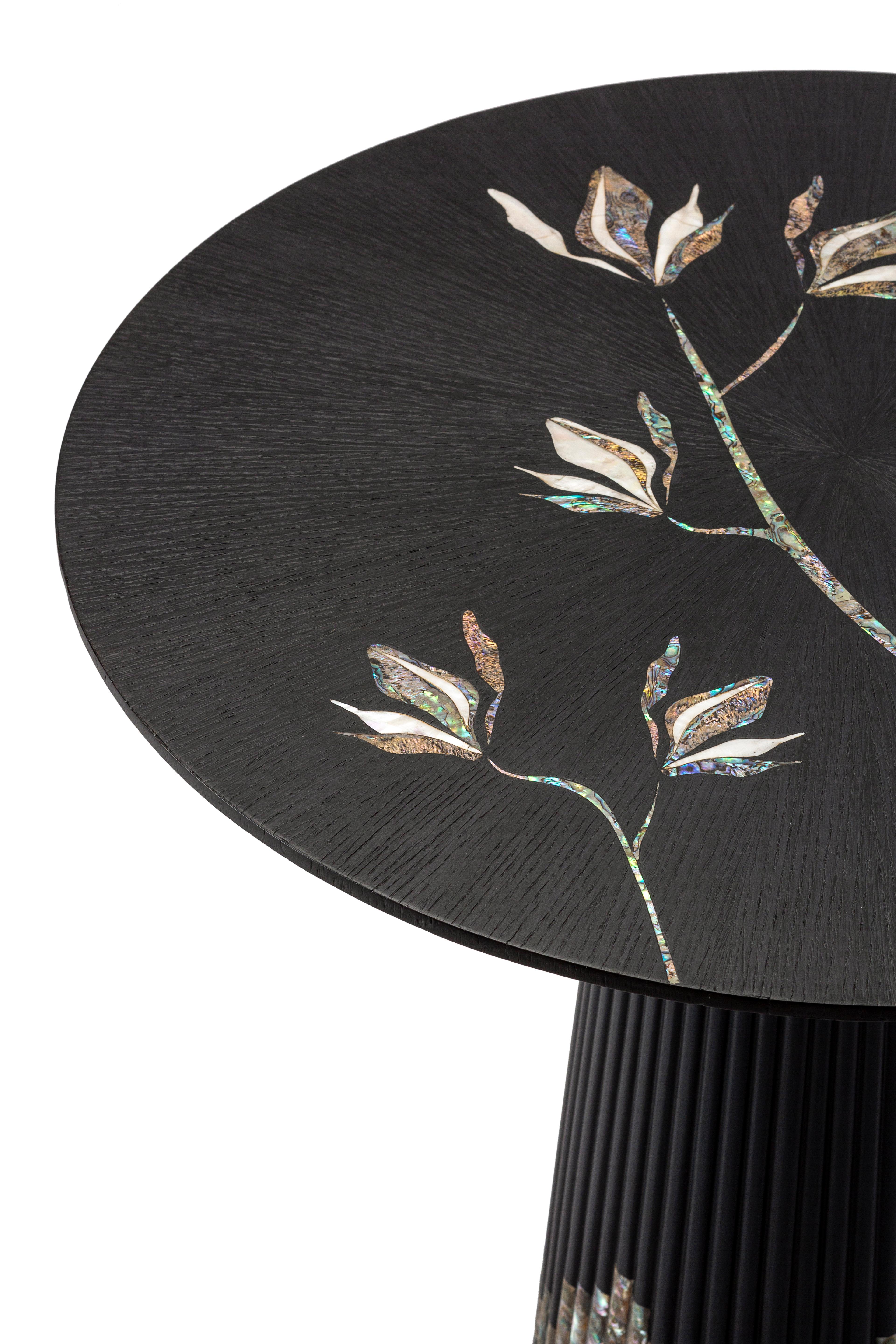 Table basse artisanale en nacre bleue véritable et bois de chêne teinté noir.
Telle une ballerine virevoltante, cette table basse est élégante et délicate. La base est soigneusement travaillée avec de la nacre bleue rare et une teinture laquée