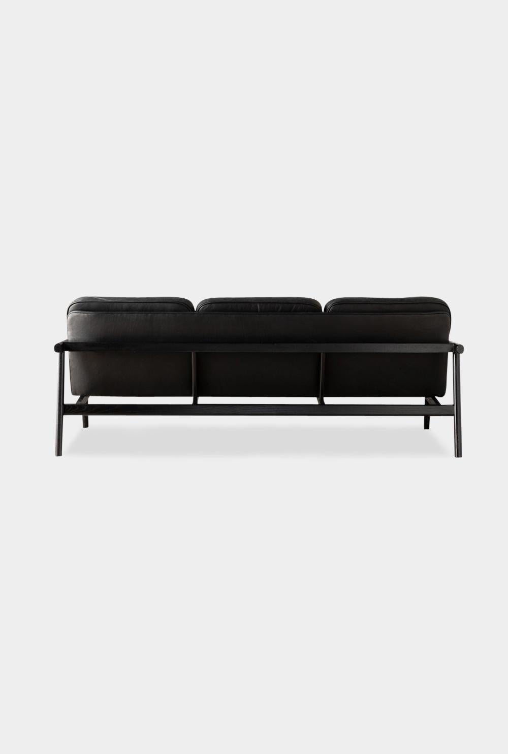This handmade solid wood constructed sofa includes handcut joinery and custom upholtered seat and seat back cushions.

This sofa is shown in our in house black leather with an ebonized oak frame.
Most Maharam upholstery fabrics have been