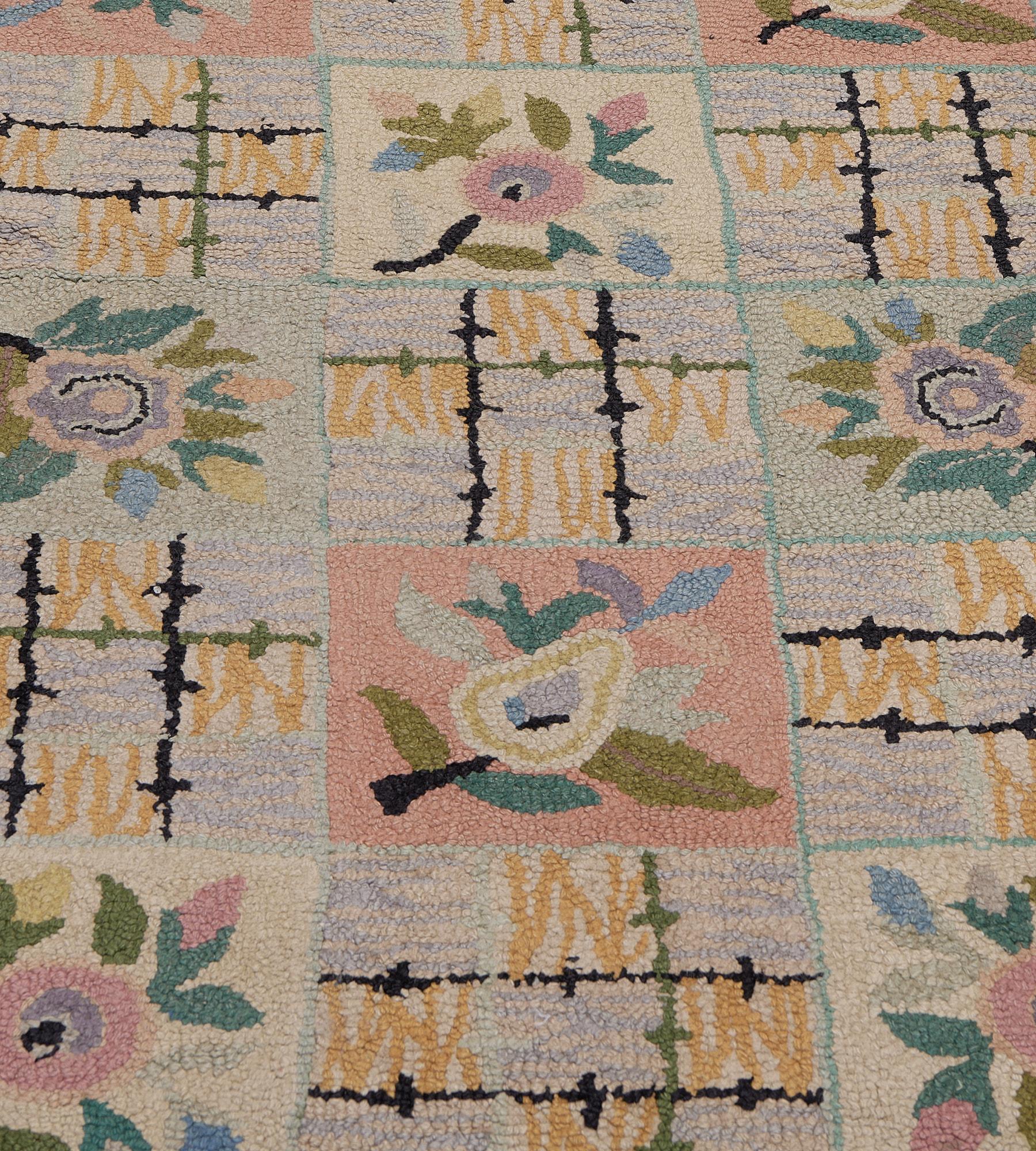 This vintage hooked runner features a central field with thirteen vertical rows of three horizontal linked square panels each containing a polychrome flowerhead alternating with square panels with two rows of charcoal-black hooked bands crossed by a