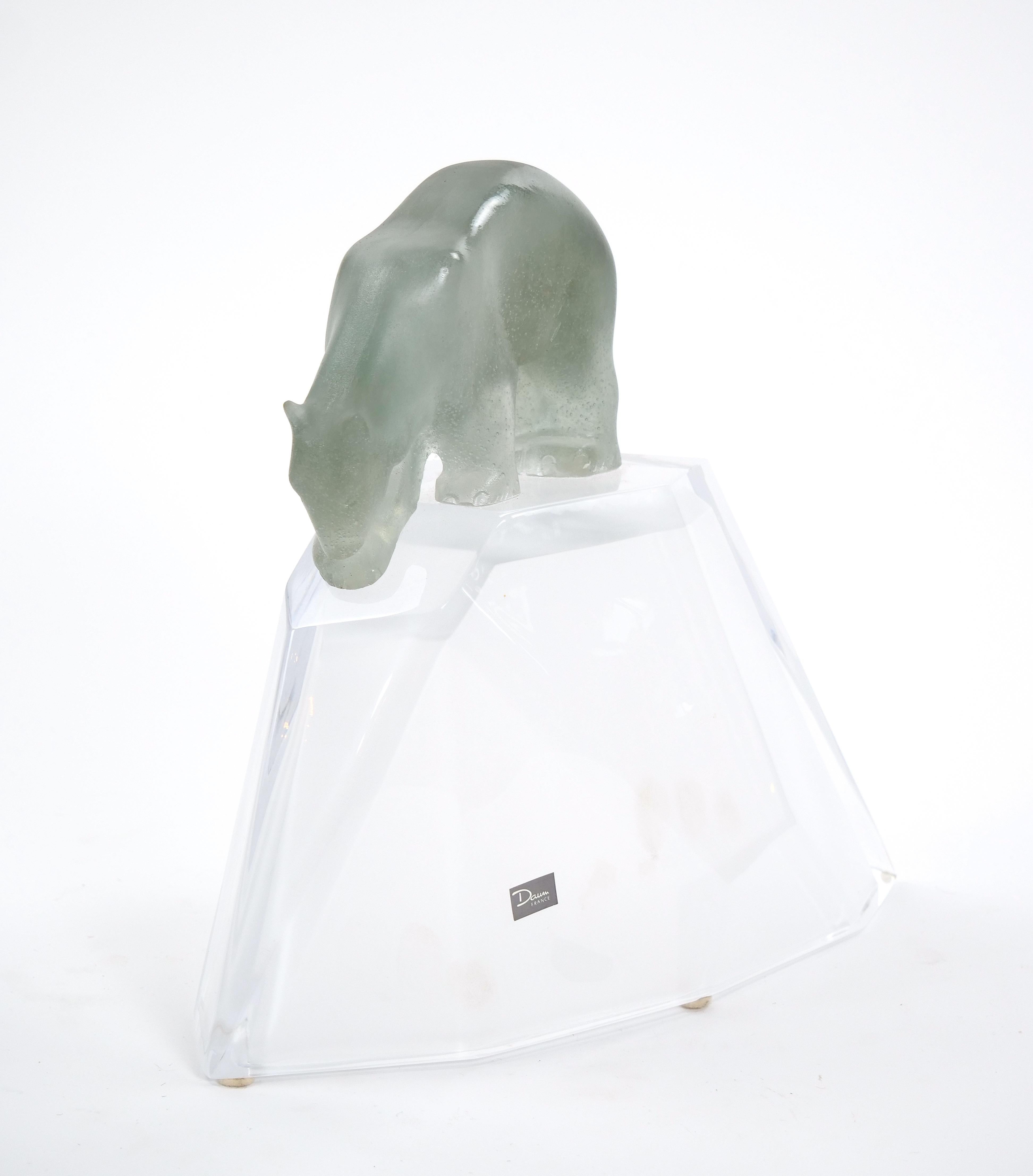 This stunning mid-20th century handcrafted and mouth-blown glass sculpture by the renowned Daum France is a true masterpiece. It beautifully captures the majestic polar bear standing proudly atop a frosty mountain ice peak. The sculpture features a