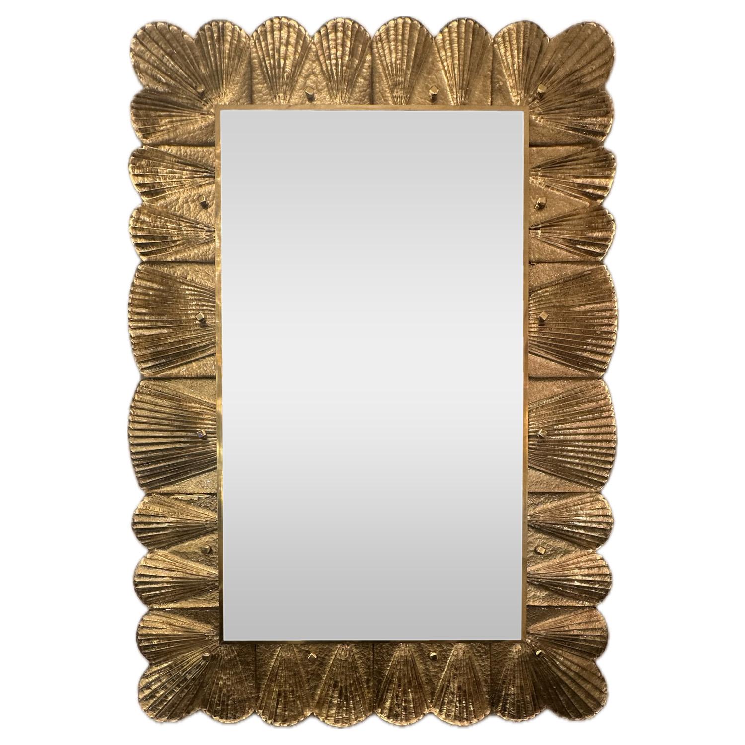 Este elegante espejo presenta azulejos hechos a mano de cristal de Murano transparente sobre pan de oro, que crean una pantalla elegante y luminosa. El distintivo motivo de concha de vieira aporta un toque de estilo Art Déco que eleva cada espacio