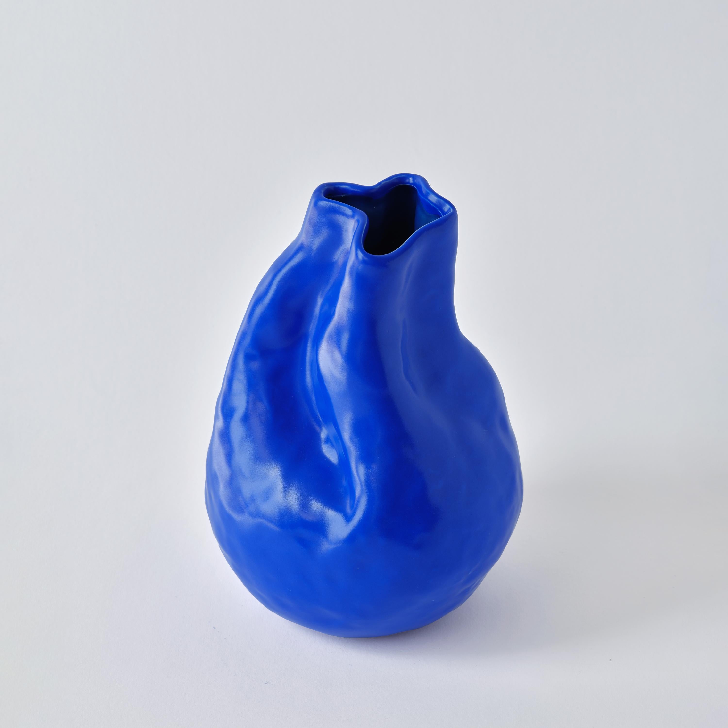 The Alexis blue hand-crafted porcelain vase from The Vibrant Touch Collection is distinguished by its vibrant cobalt blue hue, inspired by the iconic work of Yves Klein. The vase's surface is a testament to textured artistry, with a finish that