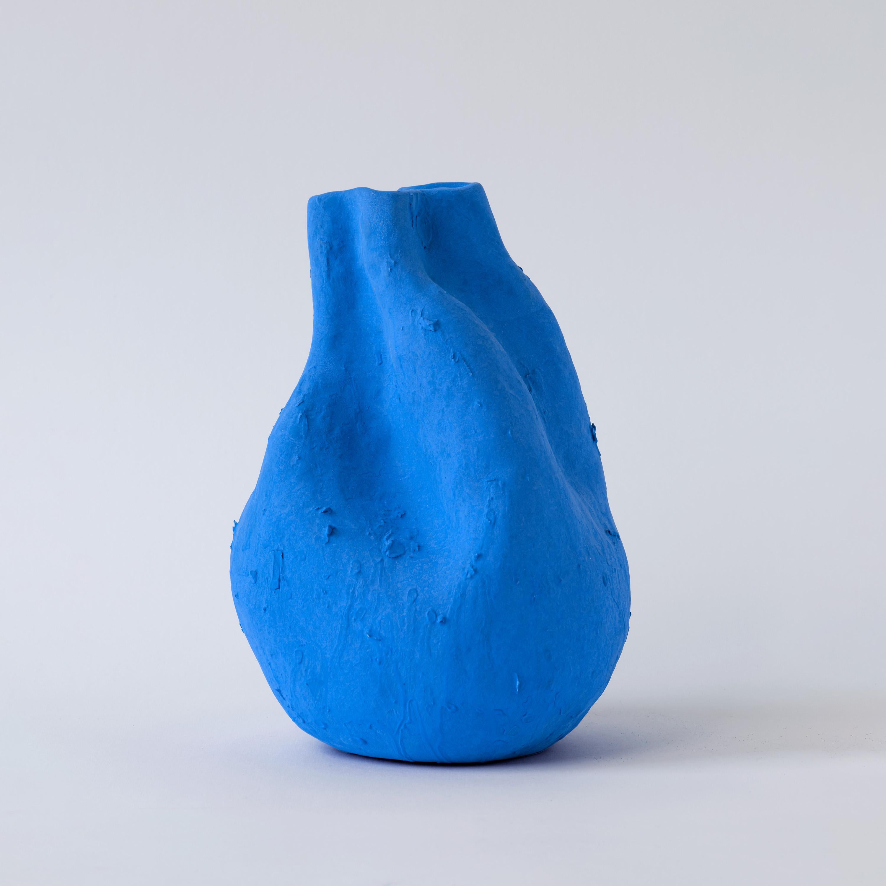 Tauchen Sie mit der Vase Alexis in die wahre Eleganz des Porzellans ein und erfreuen Sie sich an den ruhigen, mattblauen Farbtönen, die die Kühnheit der Kreativität von Yves Klein widerspiegeln. Die natürliche Form der Vase unterstreicht die