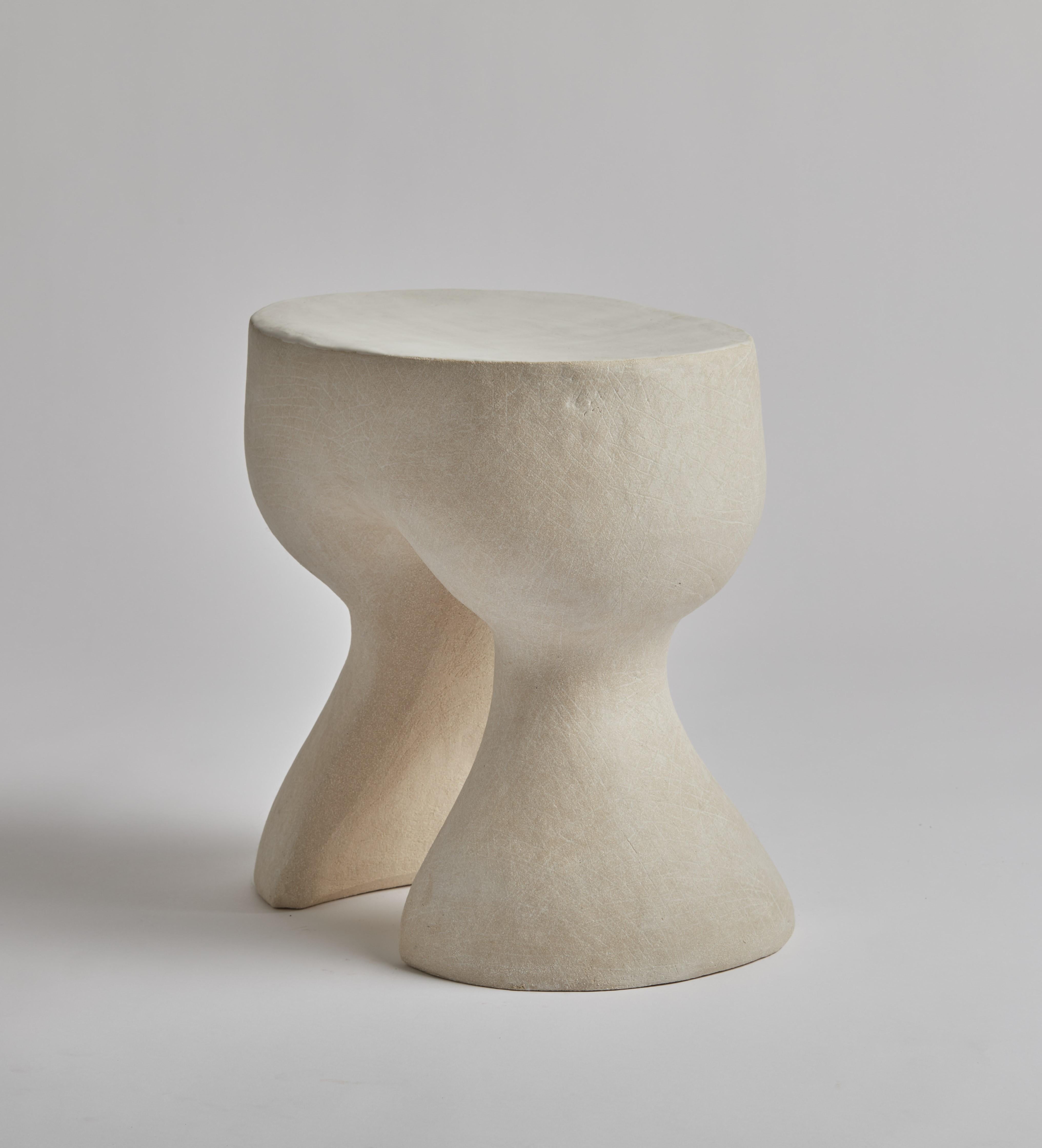 Cette table d'appoint est fabriquée à la main en grès blanc avec un plateau émaillé en dolomie.  Inspirée par les douces courbes sensuelles des œuvres du sculpteur Jean Hans Aup, Kerry Hastings fabrique ses formes à la main en utilisant la technique