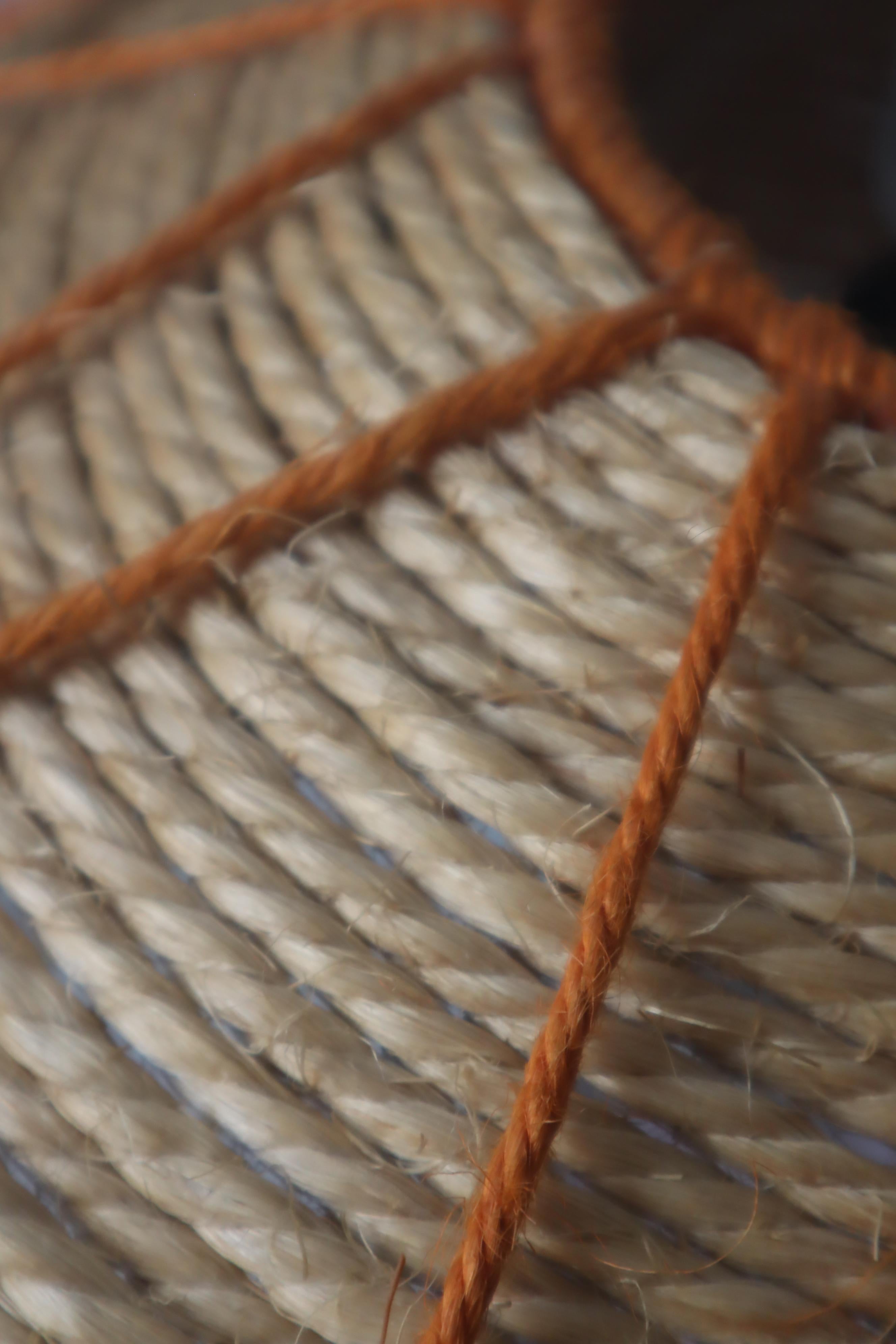 This unique hand made sisal lamp is a piece from the 1970s, it has a round lampshade with sisal covering. it is a nice piece which is not so common. inside the lamp is a white metal that holds the bulb.  this lamp is very decorative and it brings