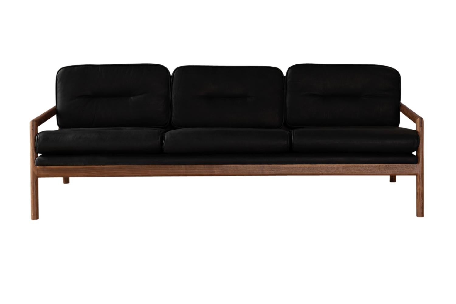 This handmade solid wood constructed sofa includes hand-cut joinery and custom upholtered seat and seat back cushions.

This sofa is shown in black leather with ebonized oak.
Most Maharam upholstery fabrics have been pre-approved.
COM and COL