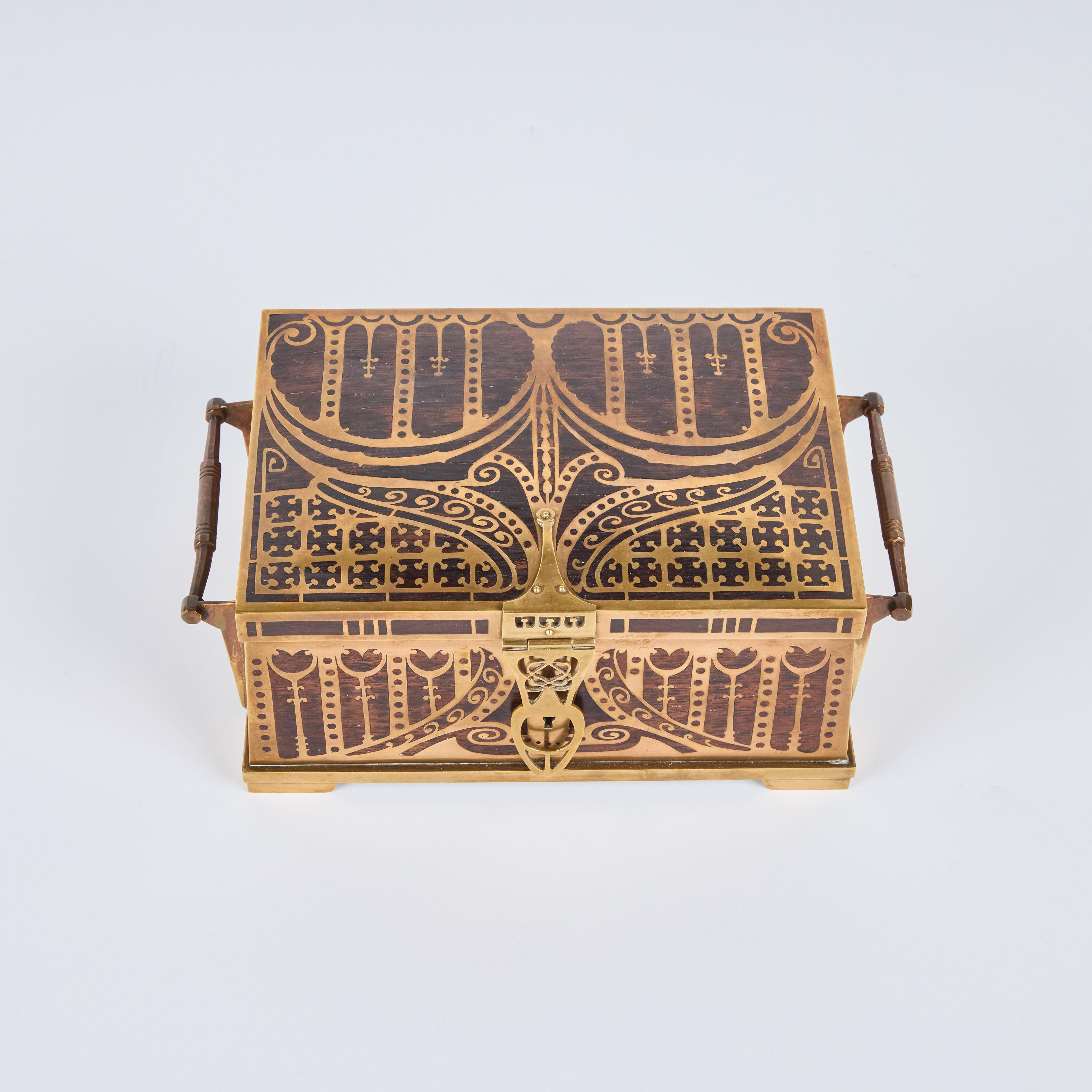 Una preciosa caja con bisagras de madera y latón hecha a mano por Erhard y Sohne.  Forrado de terciopelo malva.  Con 2 llaves. 