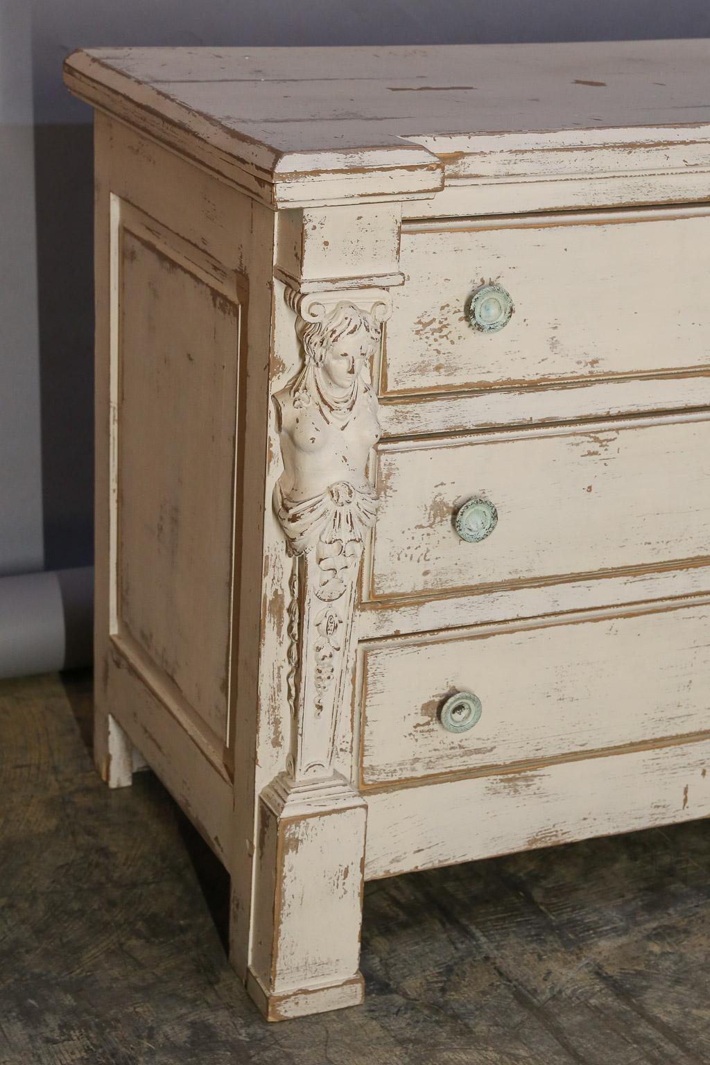 Chest with six drawers has been painted and hand-distressed to look old.

Each side of chest features a carved carytid, in the neoclassical manner,
as the only ornamentation aside from paneled sides.

White distressed mirror is a companion