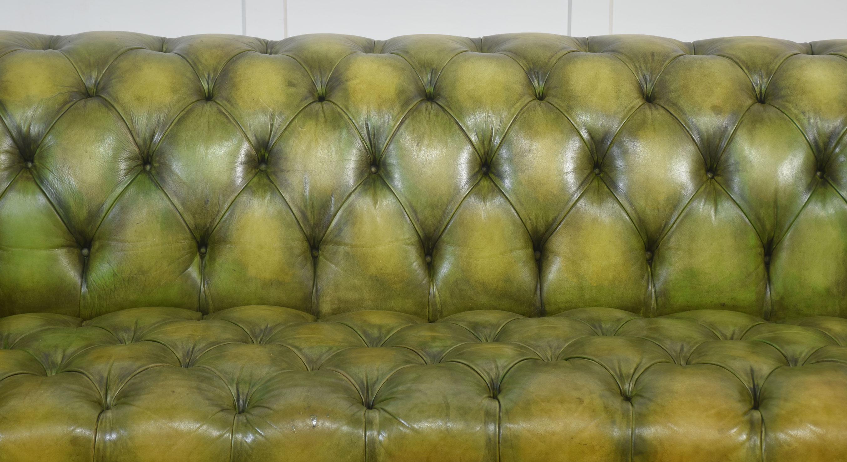 Ein auffälliges Chesterfield-Sofa, gepolstert mit handgefärbtem grünem Leder, das eine schöne Alterspatina aufweist. Dieses schöne Beispiel traditioneller englischer Handwerkskunst zeichnet sich durch die klassische, tief geknöpfte Rückenlehne und