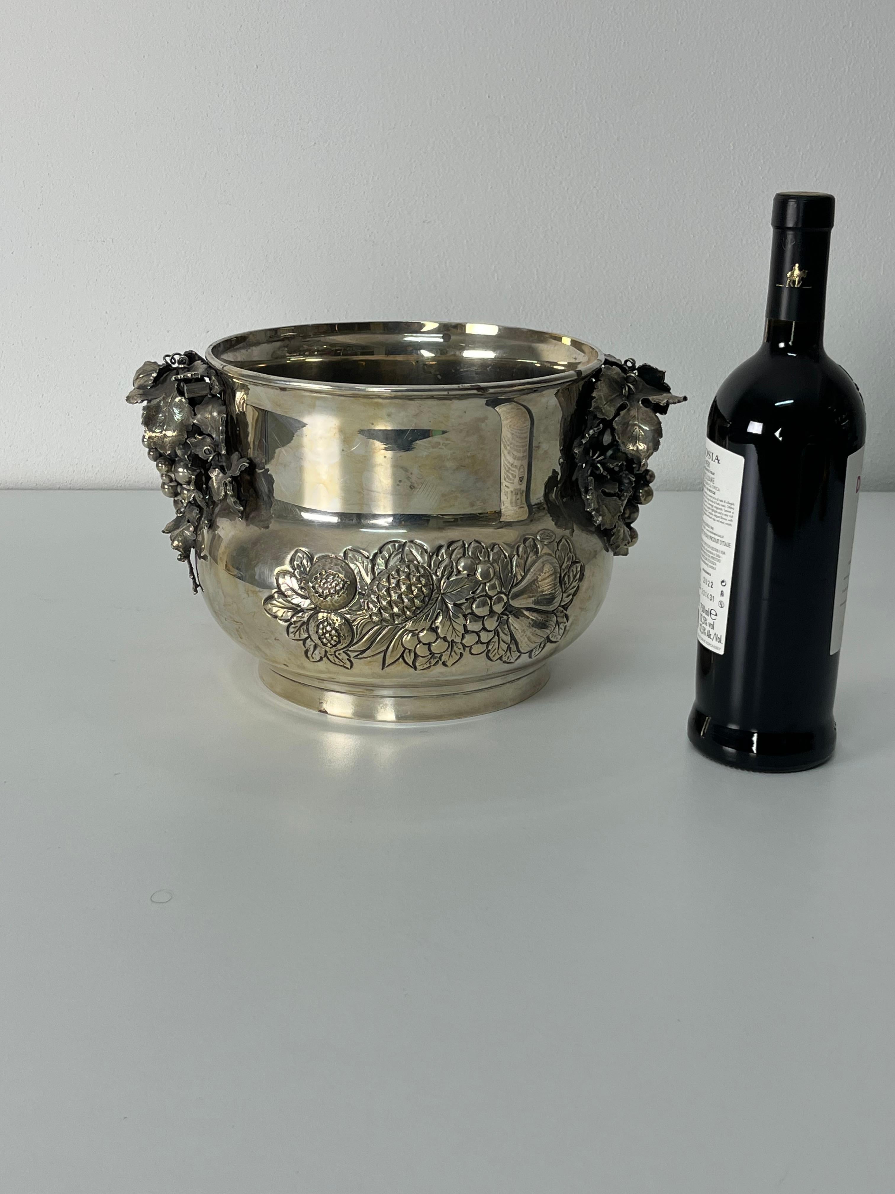 Seau à champagne en argent 925 gravé à la main, années 1980
Fait en Italie.
Décorée de motifs floraux et de grappes de raisin.
Régulièrement estampillés avec des poinçons d'État.
Diamètre 32 cm, hauteur 20 cm, poids 2266 grammes.
Bon état, avec des