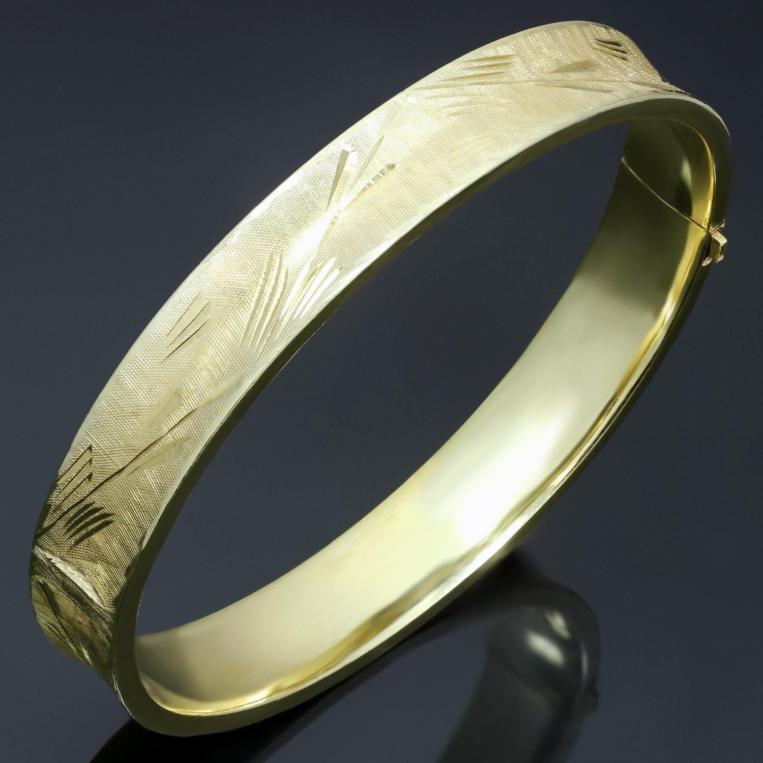 This elegant vintage bangle bracelet is crafted in 14k yellow gold and features hand-engraved filigree details. Made in United States circa 1980s. Measurements: 0.35