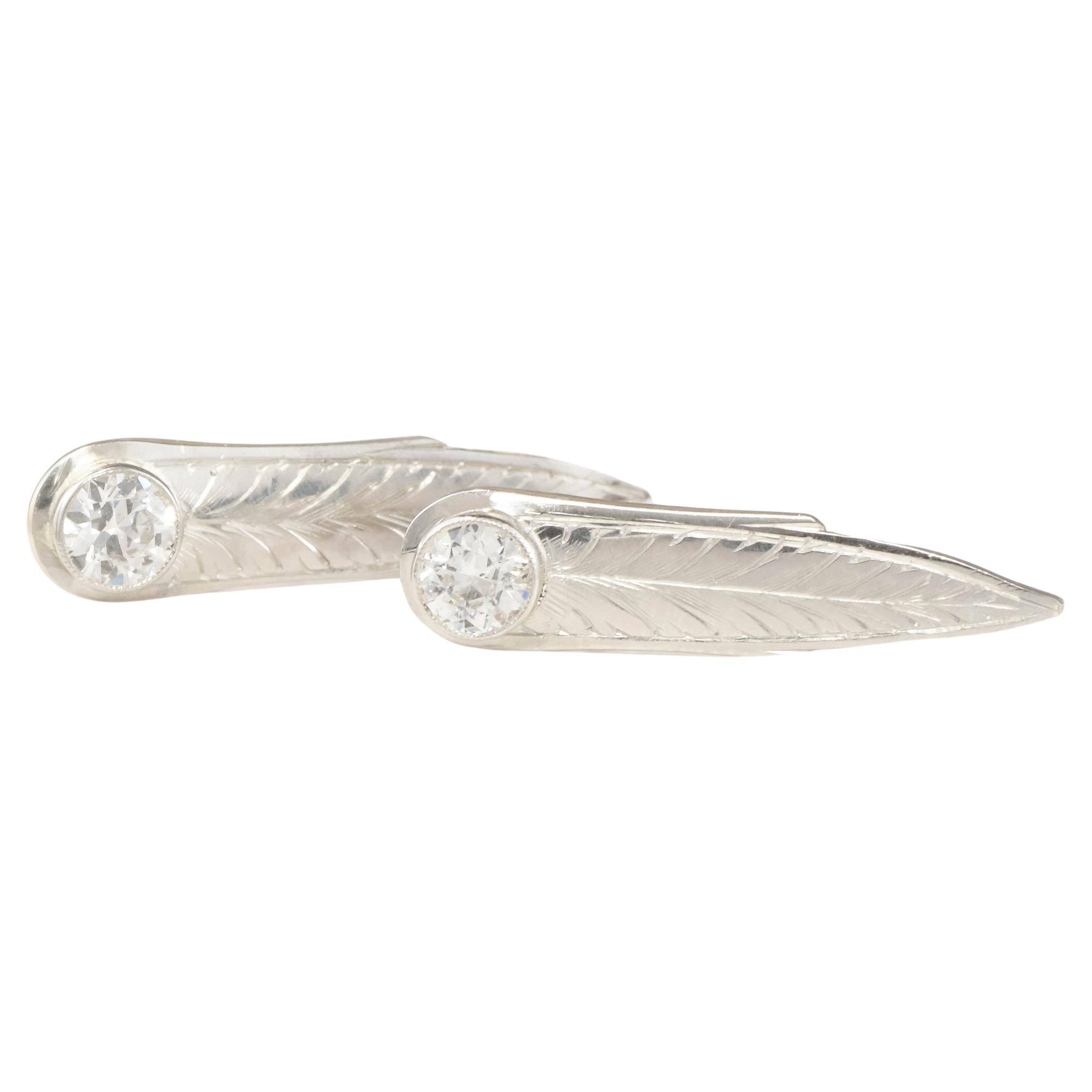 Once part of an elegant 1920's Art Deco period brooch, these stylish earrings combine fiery European cut diamonds with a vertical drop of hand engraved leaves or feathers.  Worn like studs, they have threaded posts for extra security.

Crafted of
