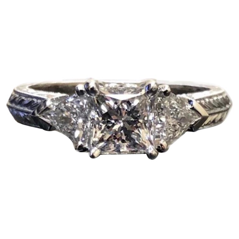 Anillo de compromiso de platino grabado a mano con tres diamantes talla princesa