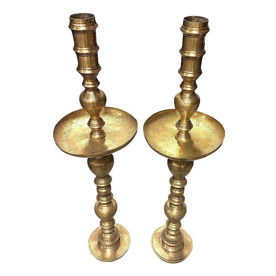 Coppia di portacandele da terra in ottone marocchino monumentale del dopoguerra con motivi geometrici incisi a mano. Questo squisito pezzo può essere utilizzato con o senza inserto votivo in vetro e misura 35 pollici di altezza, con un piatto