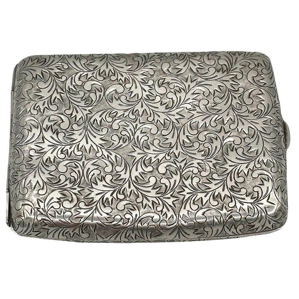 The original late Edwardian cigarette case with an intricate florentine hand-etched design along the front and back of the case showcasing delicate craftsmanship and attention to detail.

Its slender form and refined aesthetic make it a