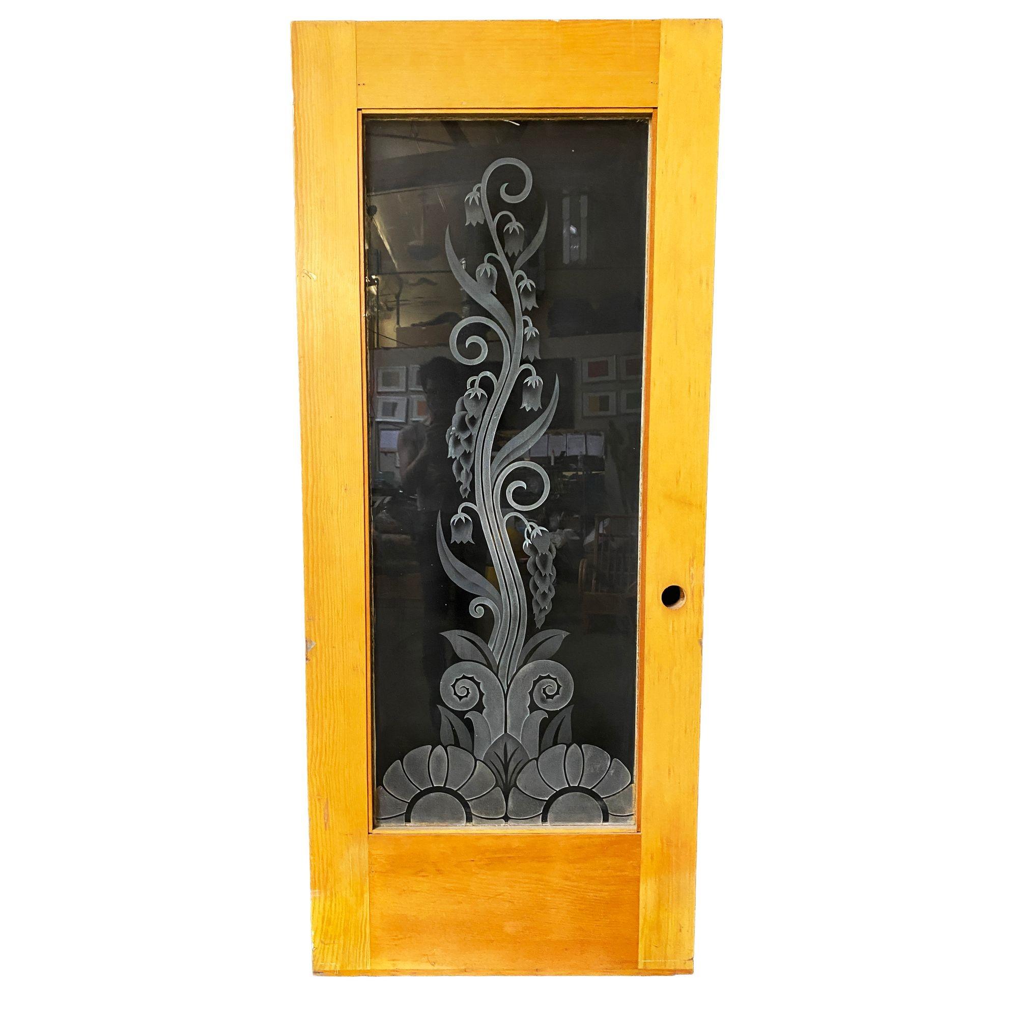 Maßgefertigte, handgeätzte/geschliffene Kunstglastür mit einem organischen Rankenmuster, das aus einer geometrischen Blume am Boden hervorgeht. Die maßgefertigte Glasscheibe ist an einem Türrahmen aus Eichenholz befestigt. 
 
Diese Tür wurde in
